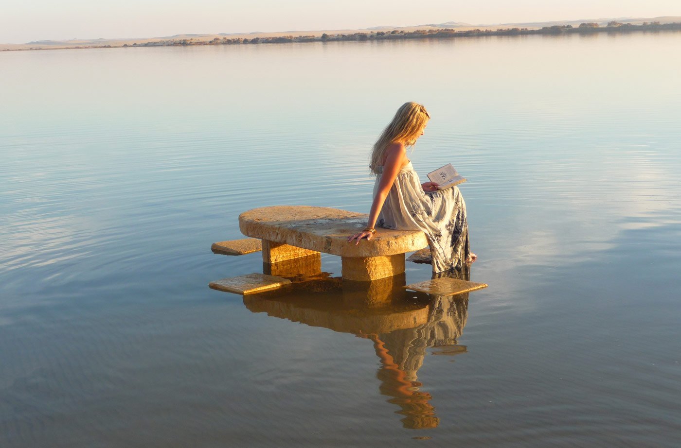 A salt-carved table set out on the still water of the lake at dusk