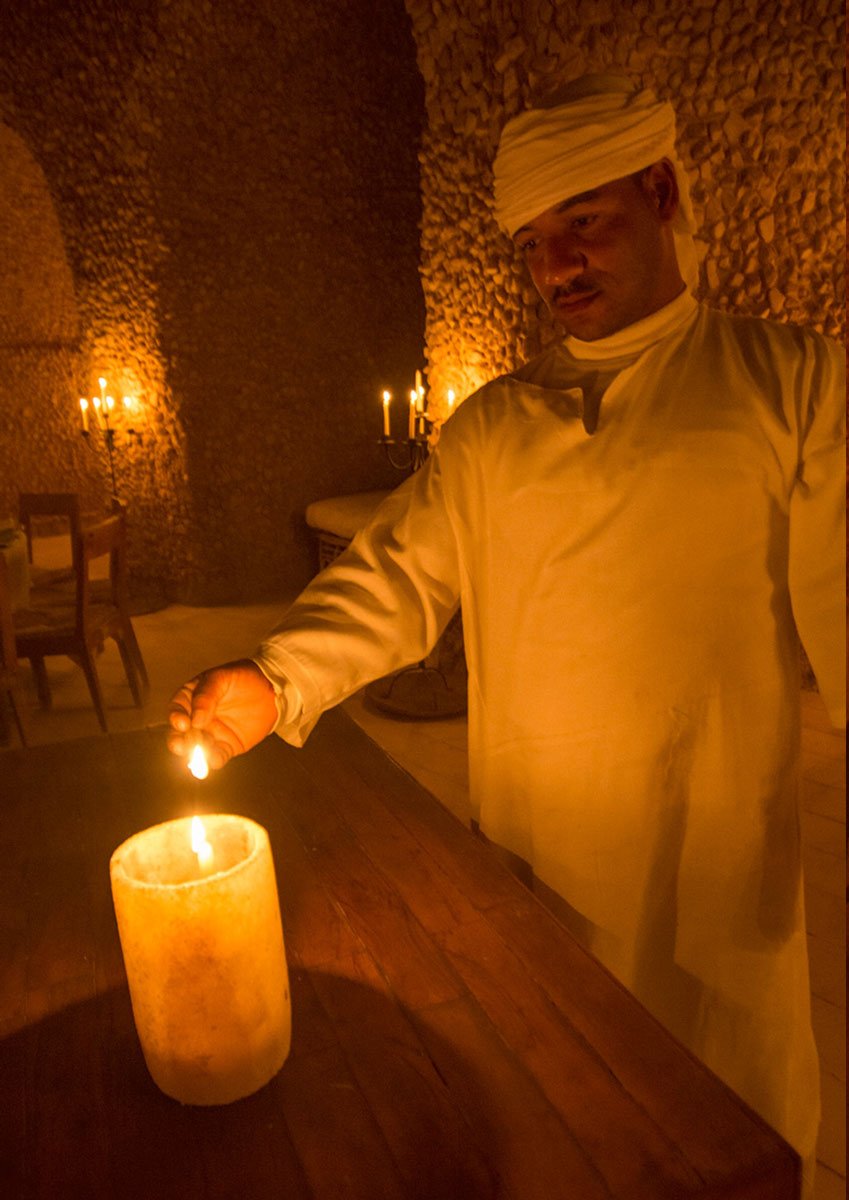 A member of staff lighting a salt candle after dark