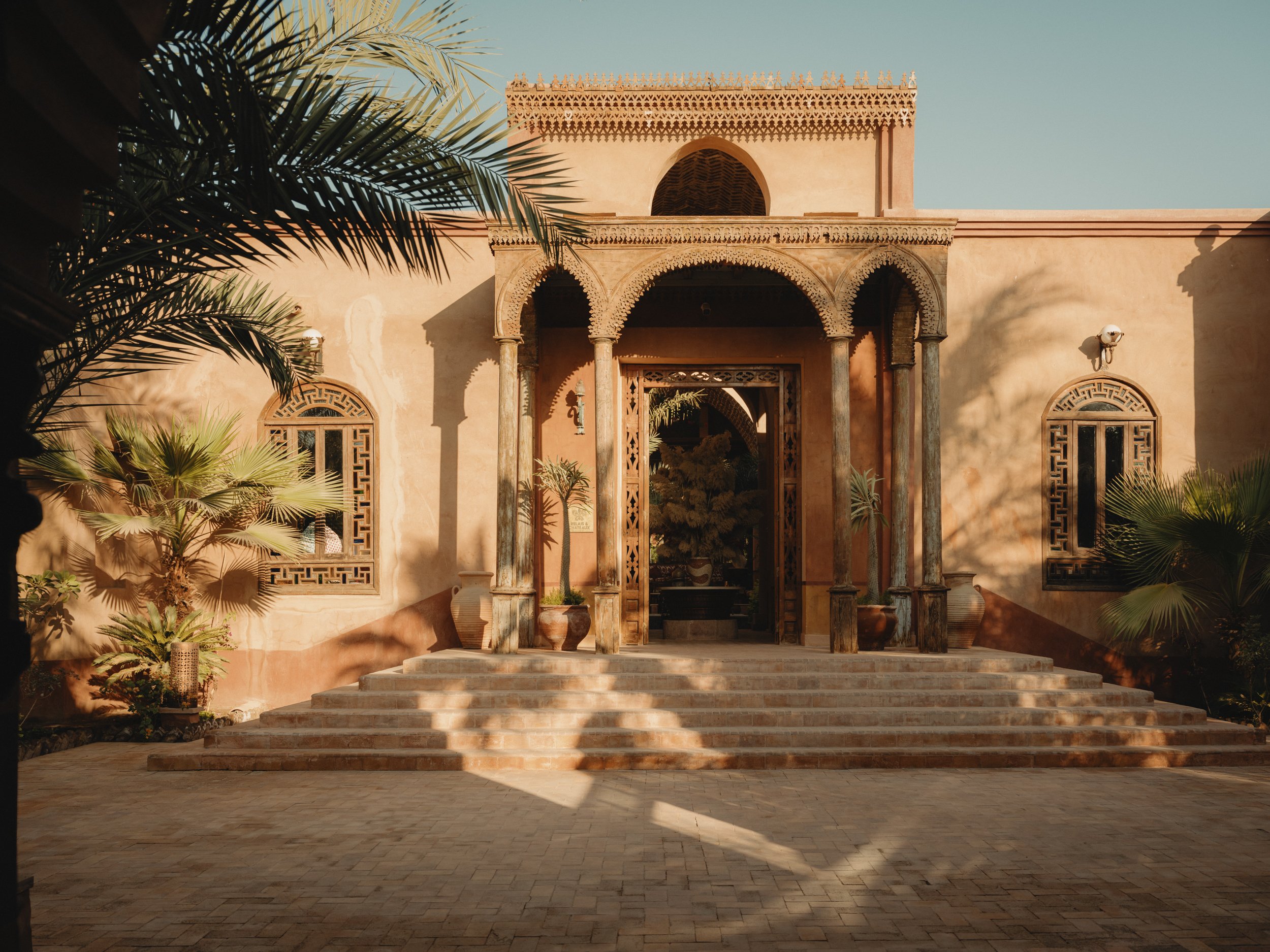 The domed, ochre facade of Al Moudira and its central arch on the Nile's west bank at Luxor