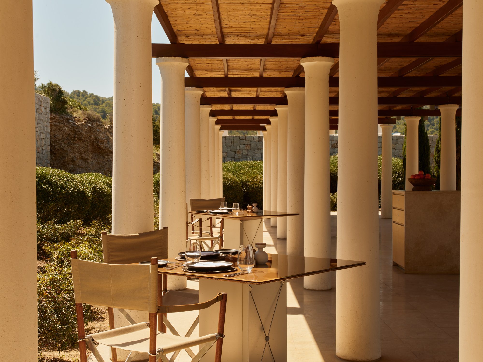A colonnaded dining terrace under a cane pergola at Amanzoe