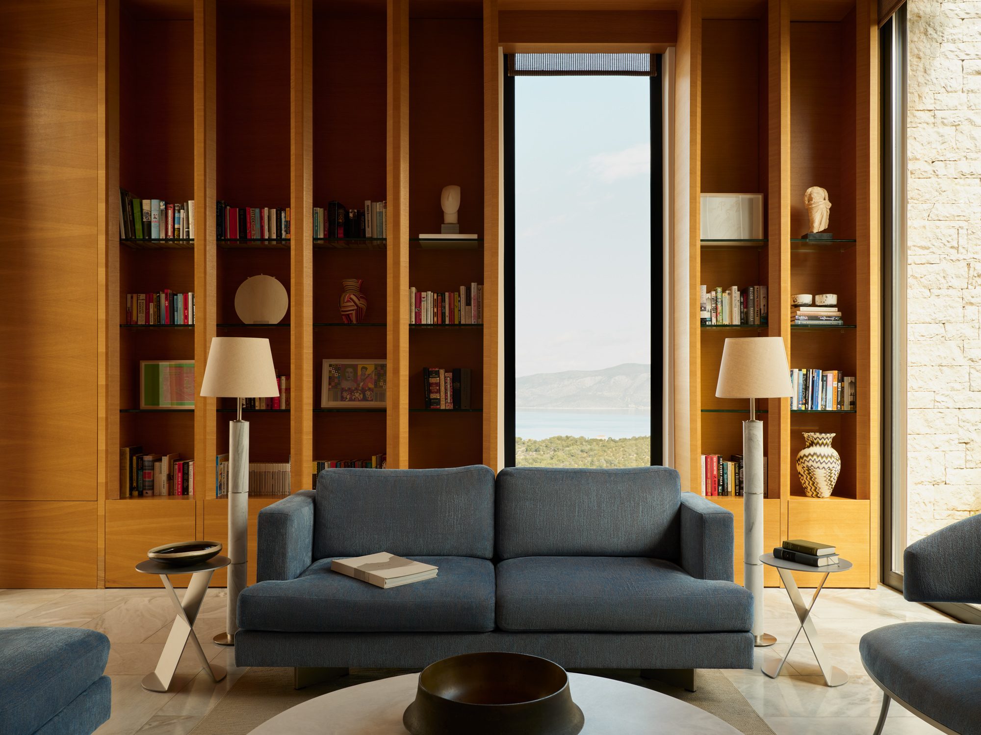 A library lounge framing the sea through a tall window