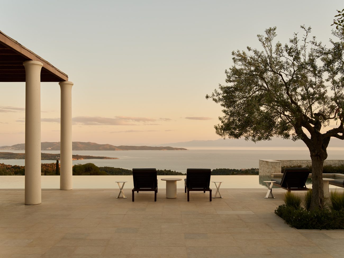 Columns and an olive tree above the Aegean at dusk