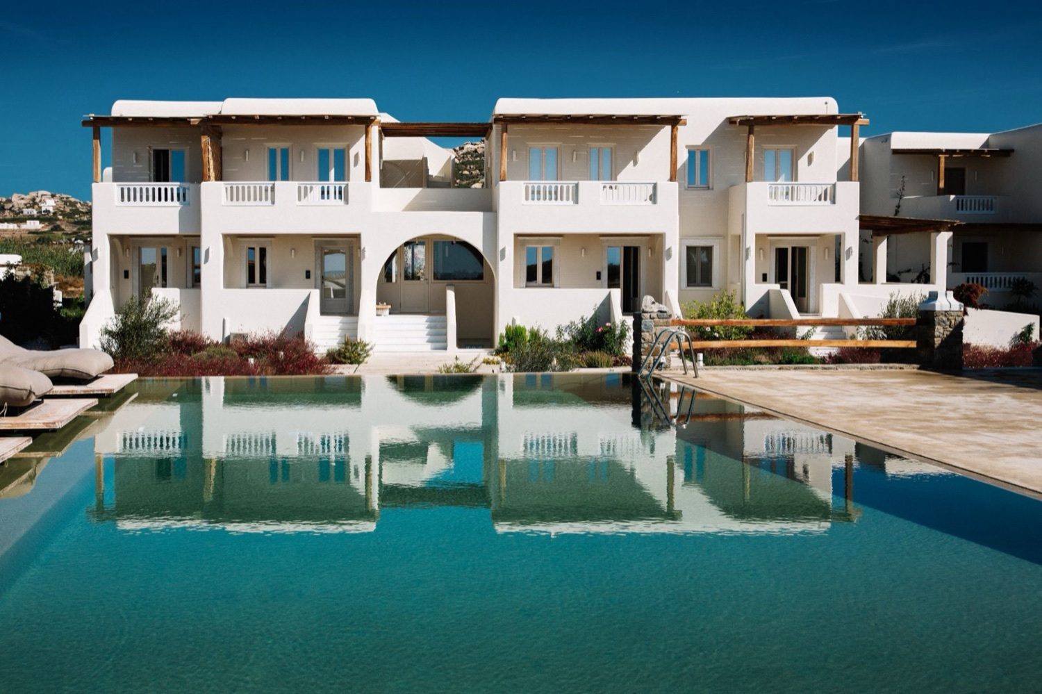 The white Cycladic buildings of Ammothines around the pool, seen from the grounds