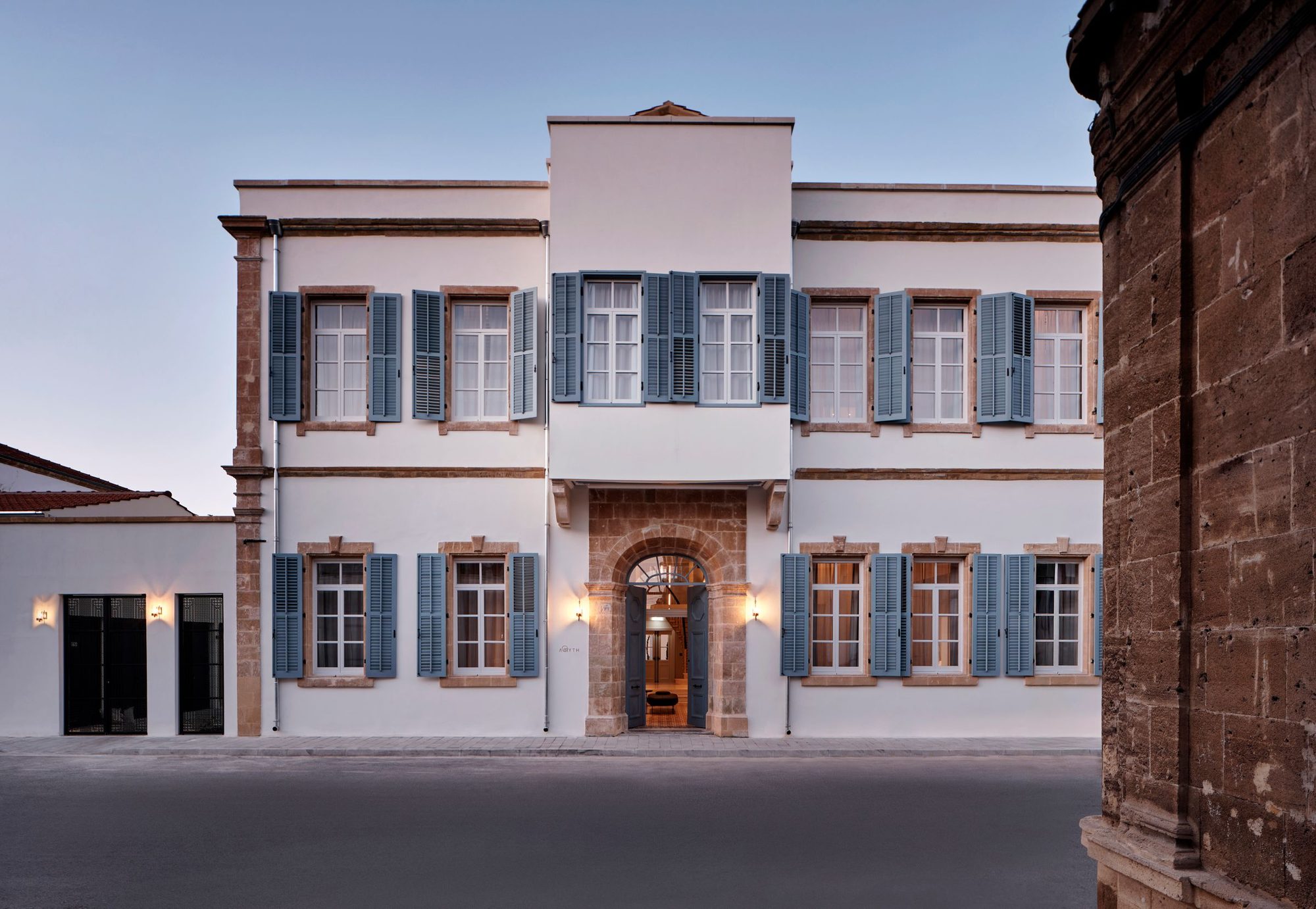 The restored facade of Amyth of Nicosia, honey stone and pale blue shutters in the walled old city