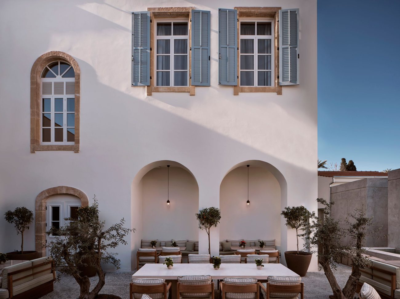 The central courtyard with its arched loggia, olive and citrus trees and a long table