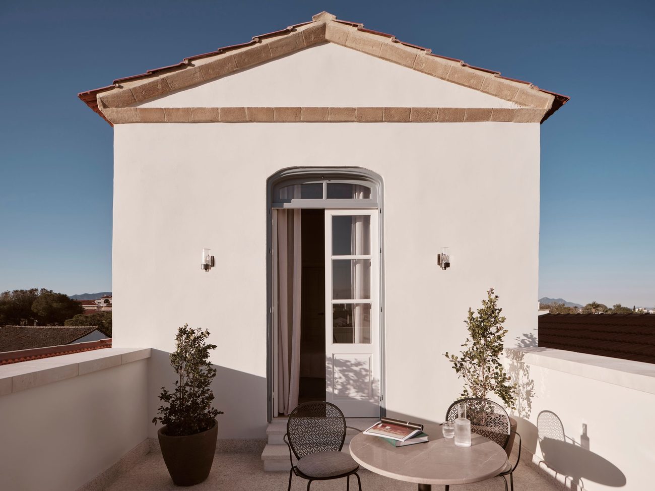 A rooftop terrace under a pediment gable with a view over the old city
