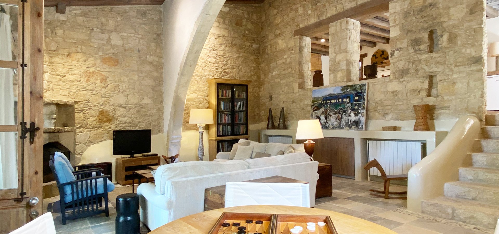 A sitting room with a lit fire and Cypriot ceramics on the wall