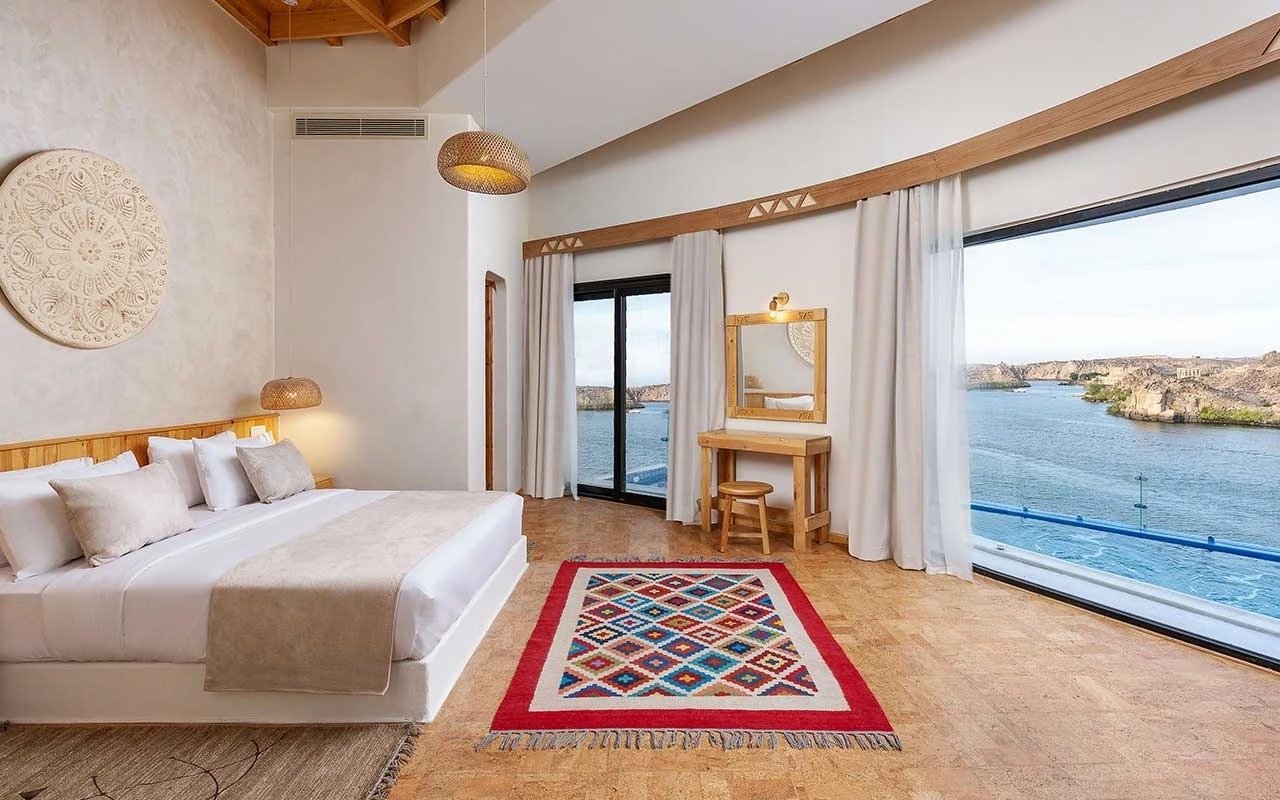A suite with curved floor-to-ceiling windows over the Nile and an infinity pool edge