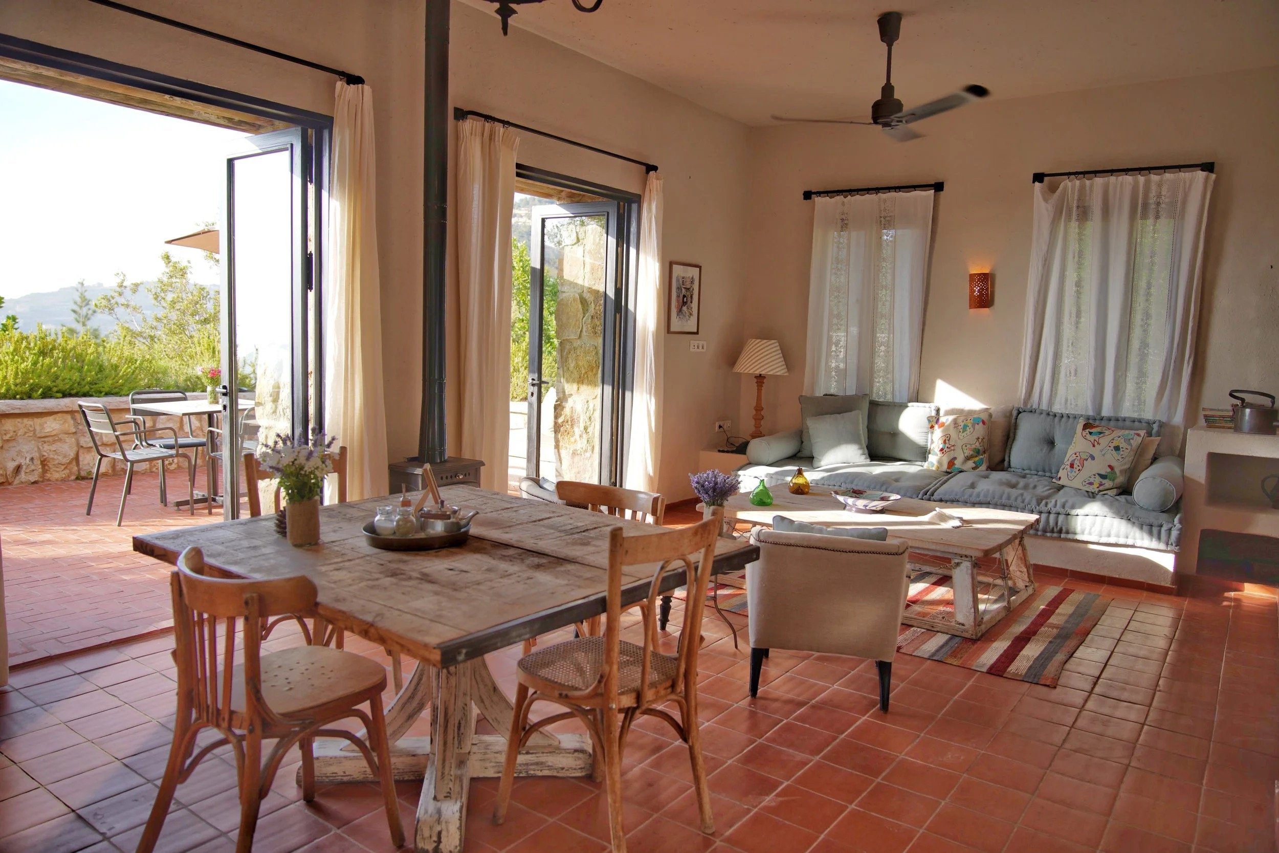 A guest house living and dining room opening onto a terrace above the Chouf valley