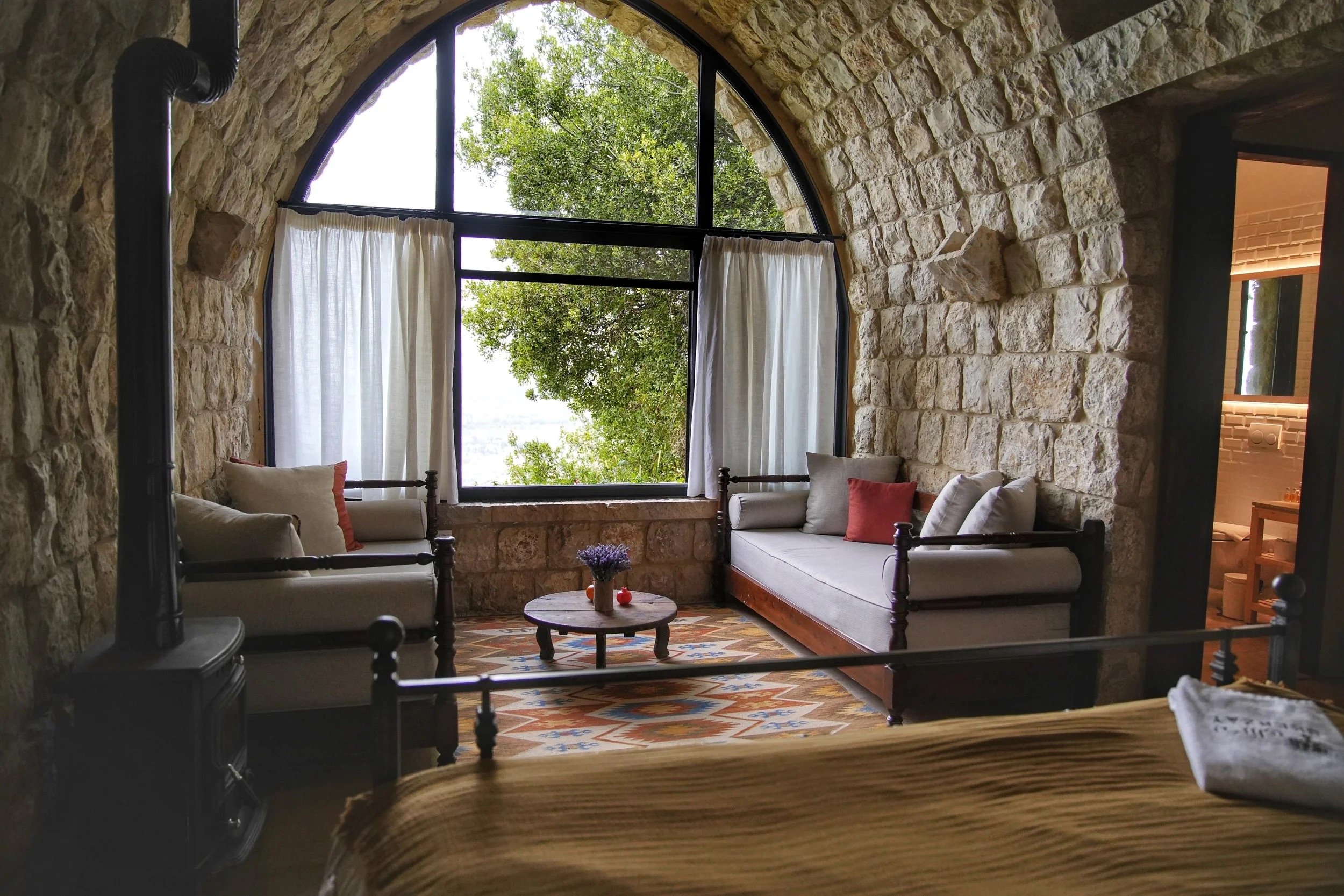 An arched stone window seat and wood stove in a Maisonette room