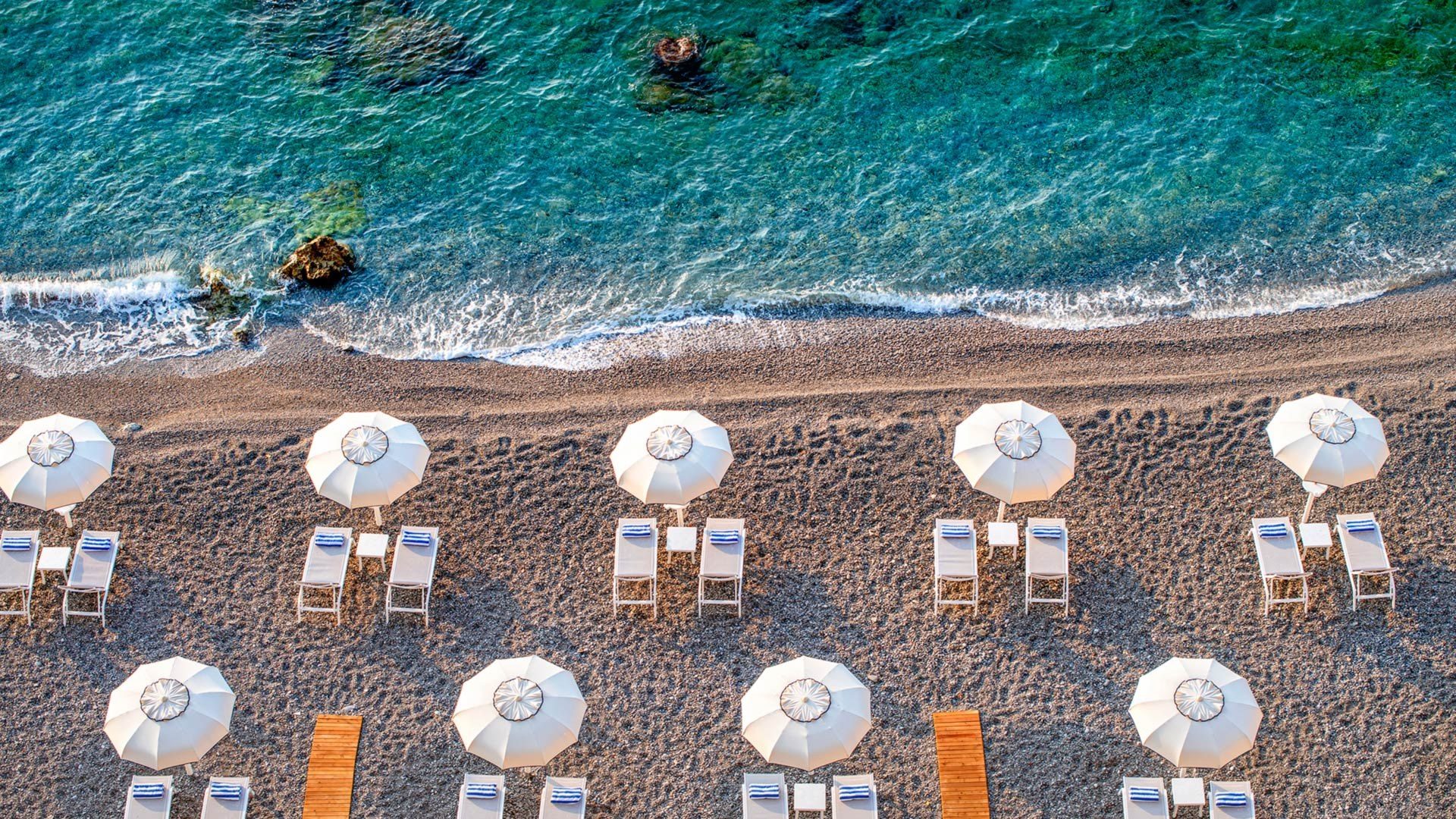 The Marinella Beach Club and jetty at the foot of the cliff