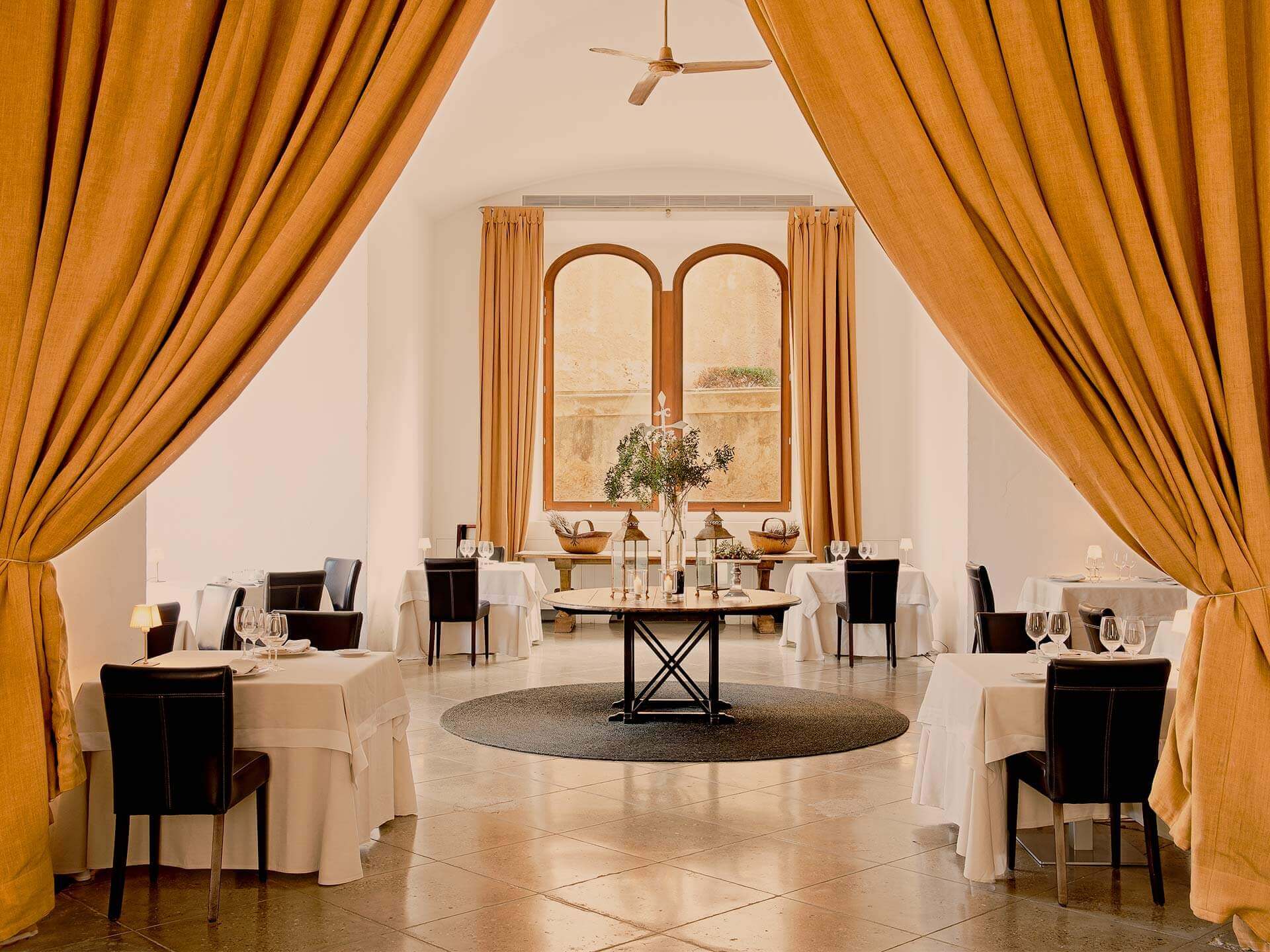 The dining room at La Fortaleza, draped curtains and white linen