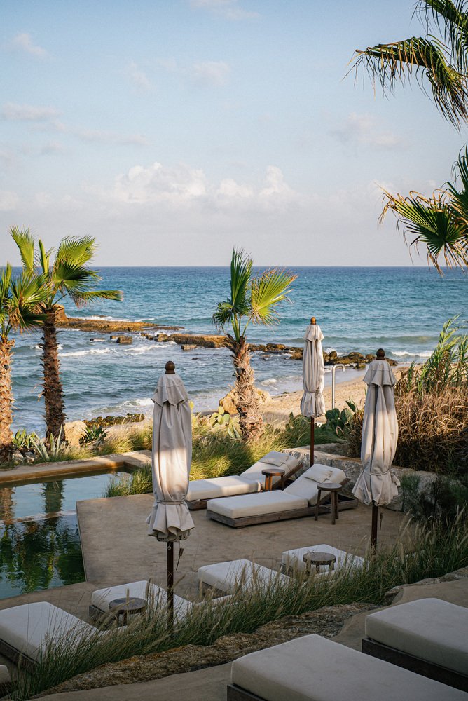Sun loungers at the pool edge above the shoreline