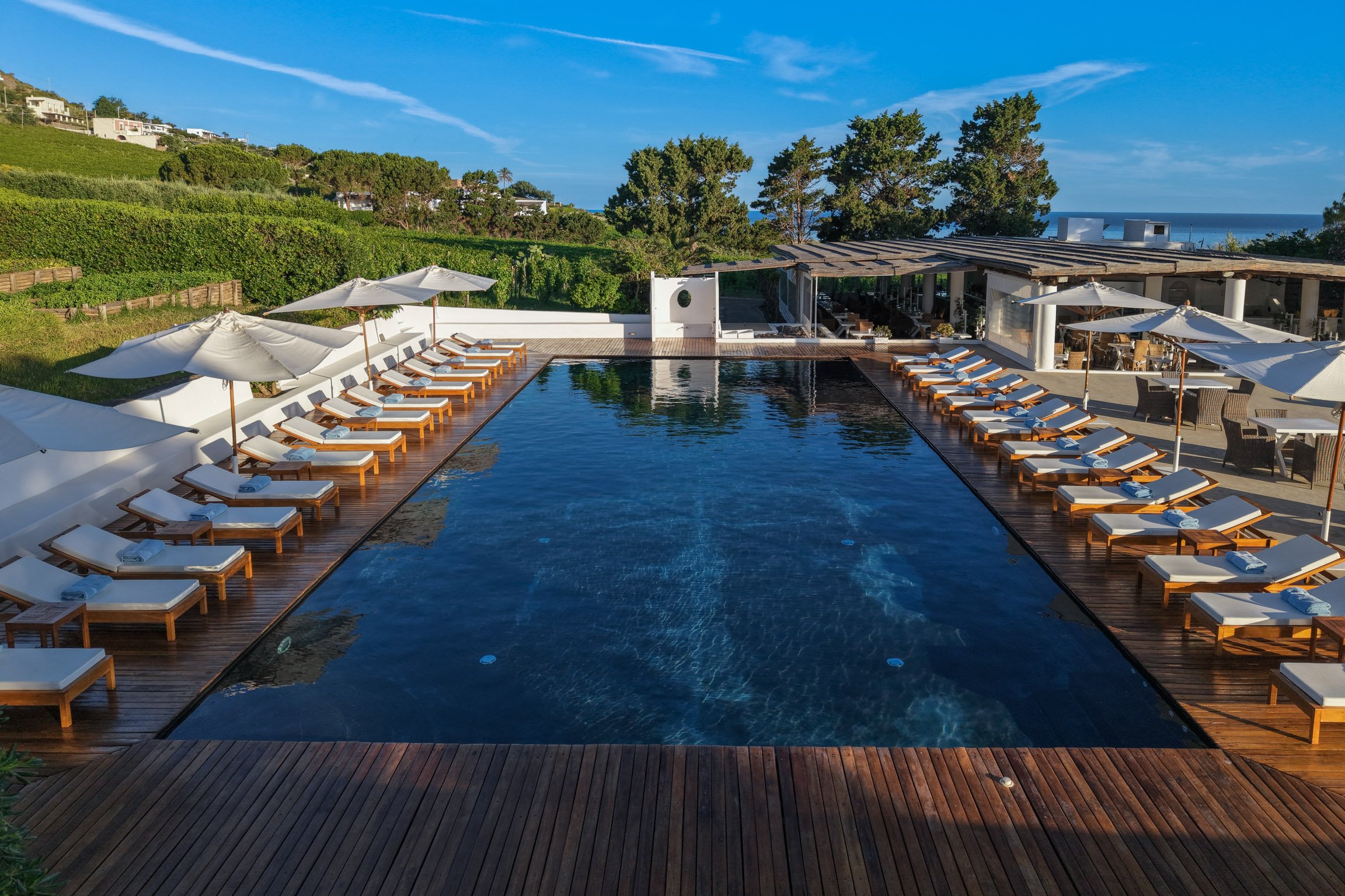The long pool with loungers and the Mediterranean beyond