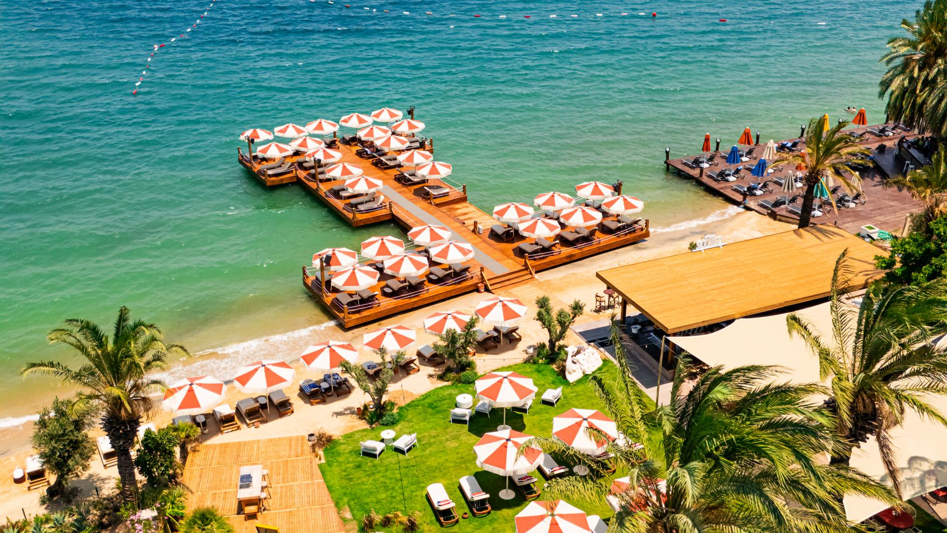 The hotel's jetties and umbrellas along the beach at Torba