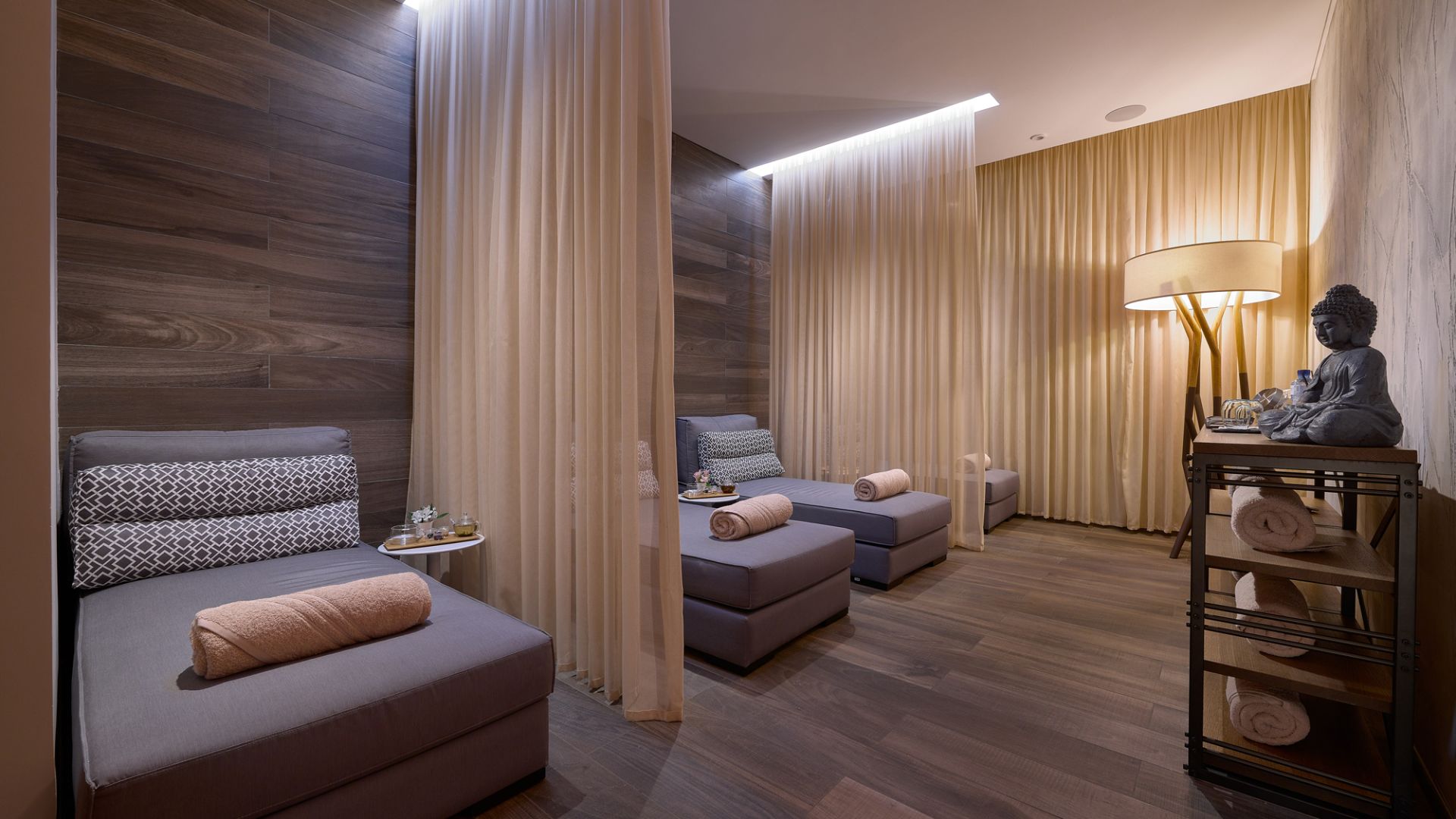 A suite living room in oak and neutral tones with soft lamplight