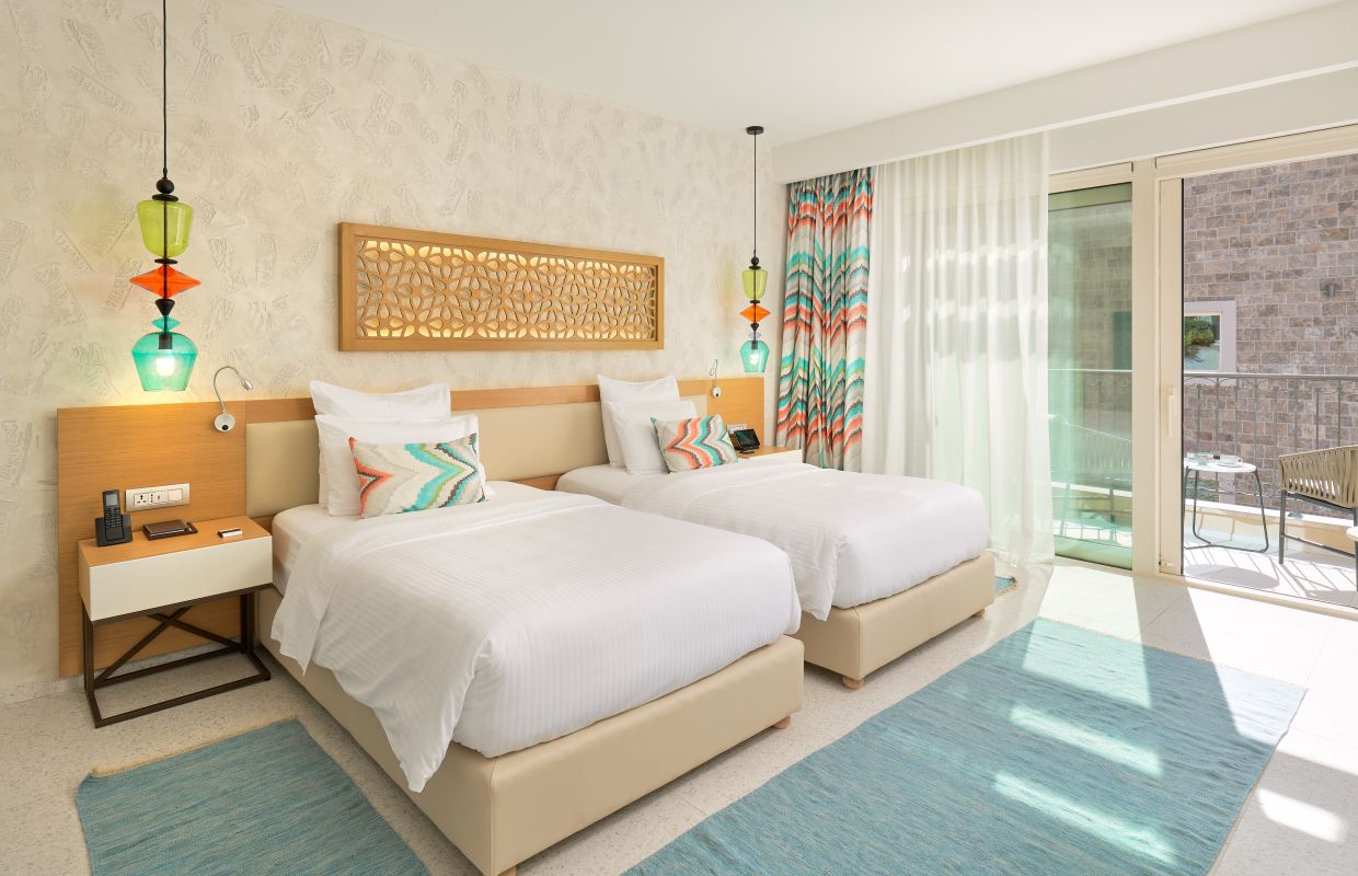 A twin room with a sea-view balcony and hand-blown glass pendant lamps
