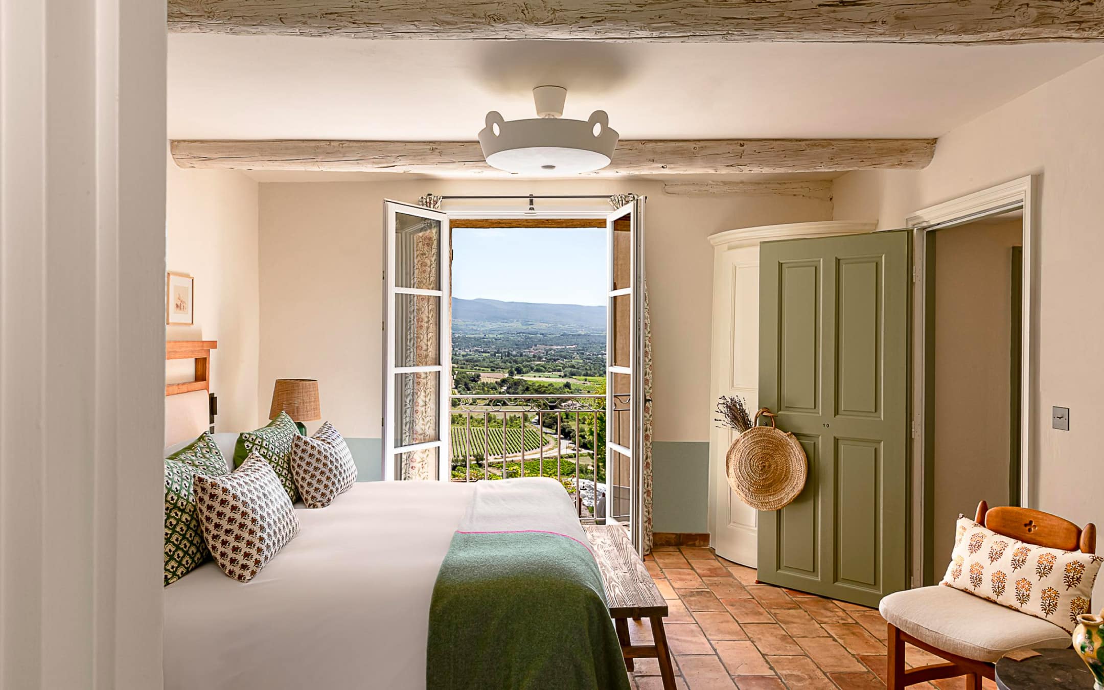 A room with beamed ceilings and French doors opening to the Vaucluse valley
