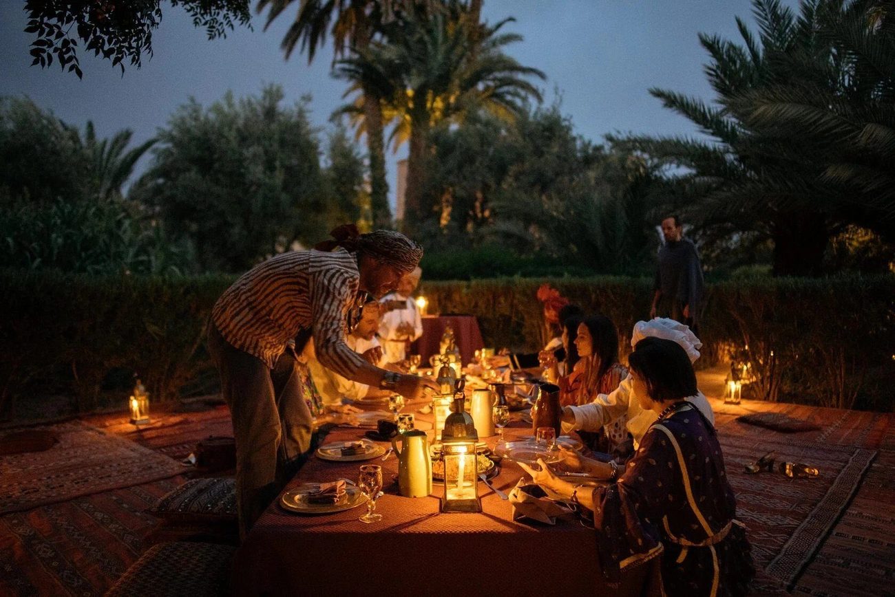A long candlelit dinner laid under the palms in the garden