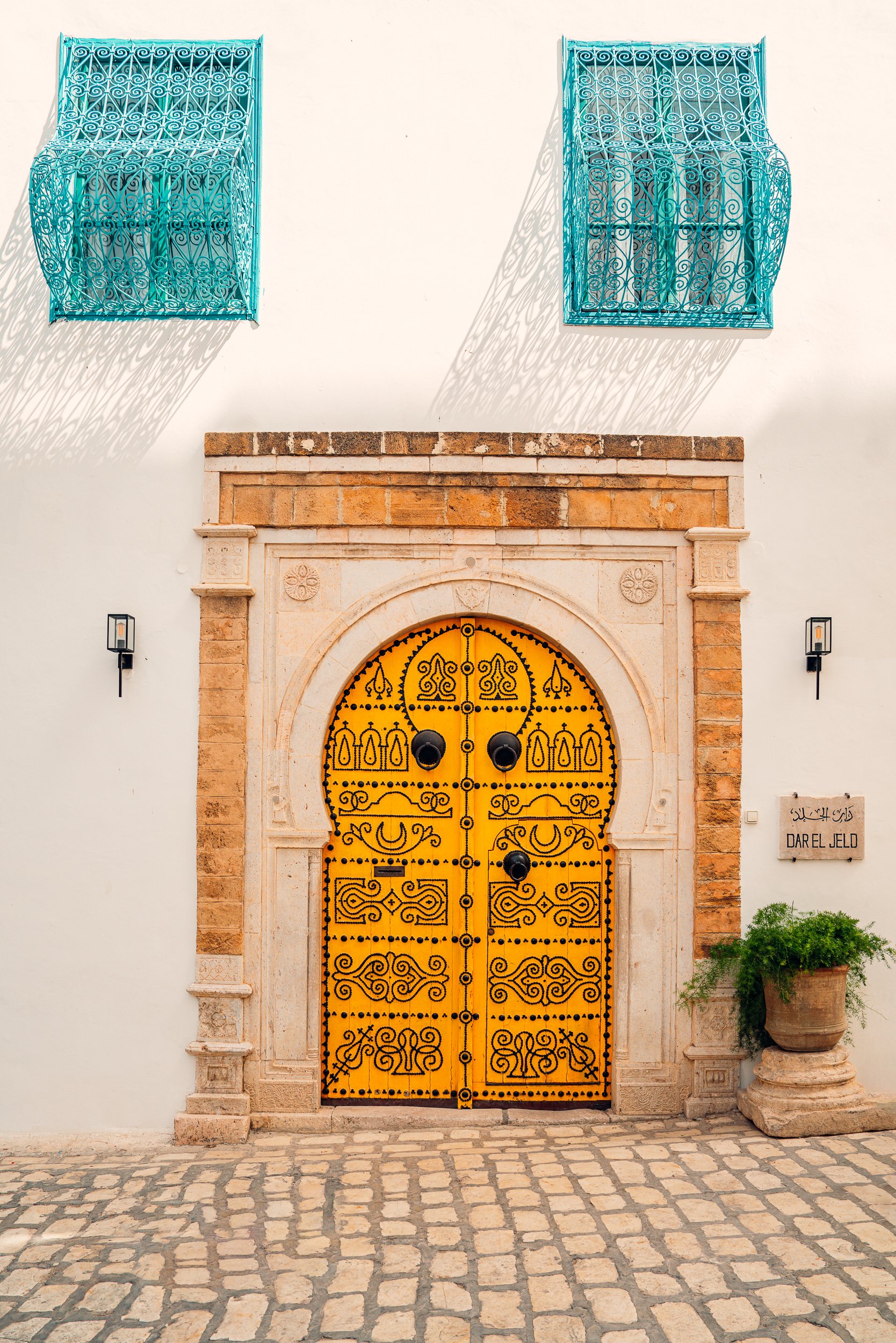 The hotel's ornate yellow studded door on a lane in the medina
