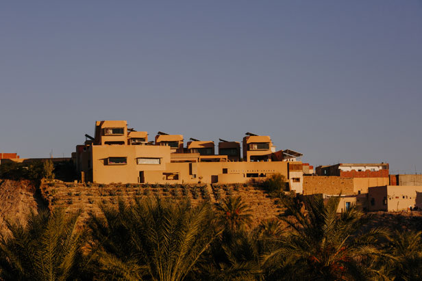 The ochre towers of Dar Hi on the ridge above the Nefta oasis at sunset