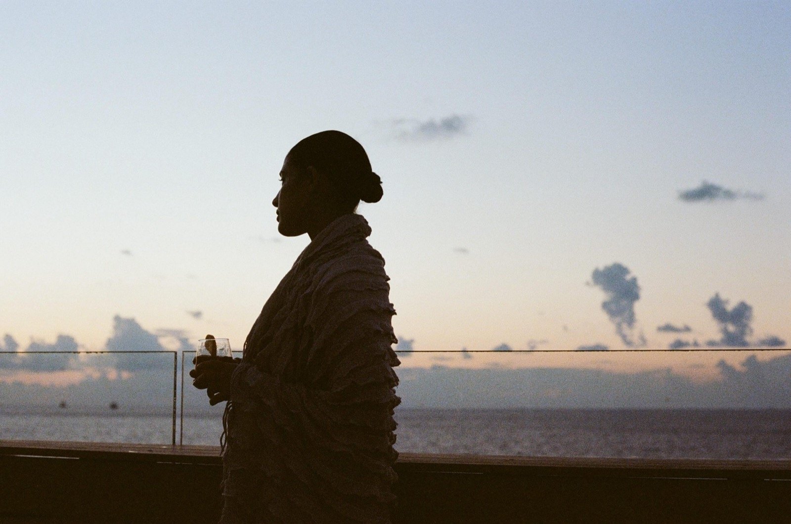 The rooftop at dusk, the Mediterranean beyond the rail