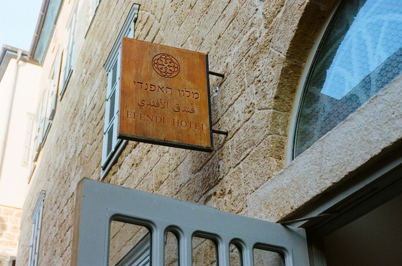 The Efendi Hotel sign on the old stone wall in an alley of Acre