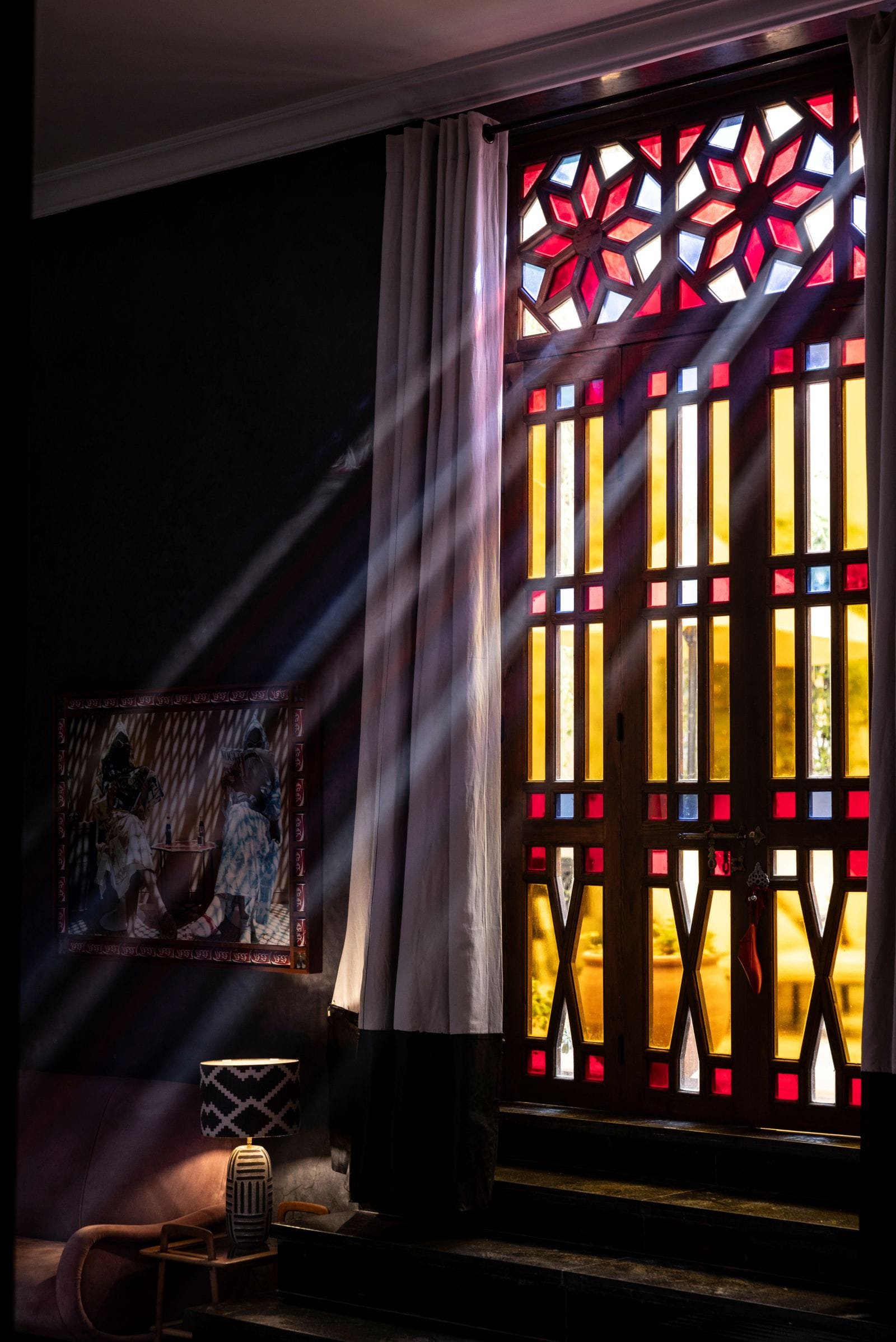 A room at El Fenn with tall stained-glass windows throwing coloured light across the floor
