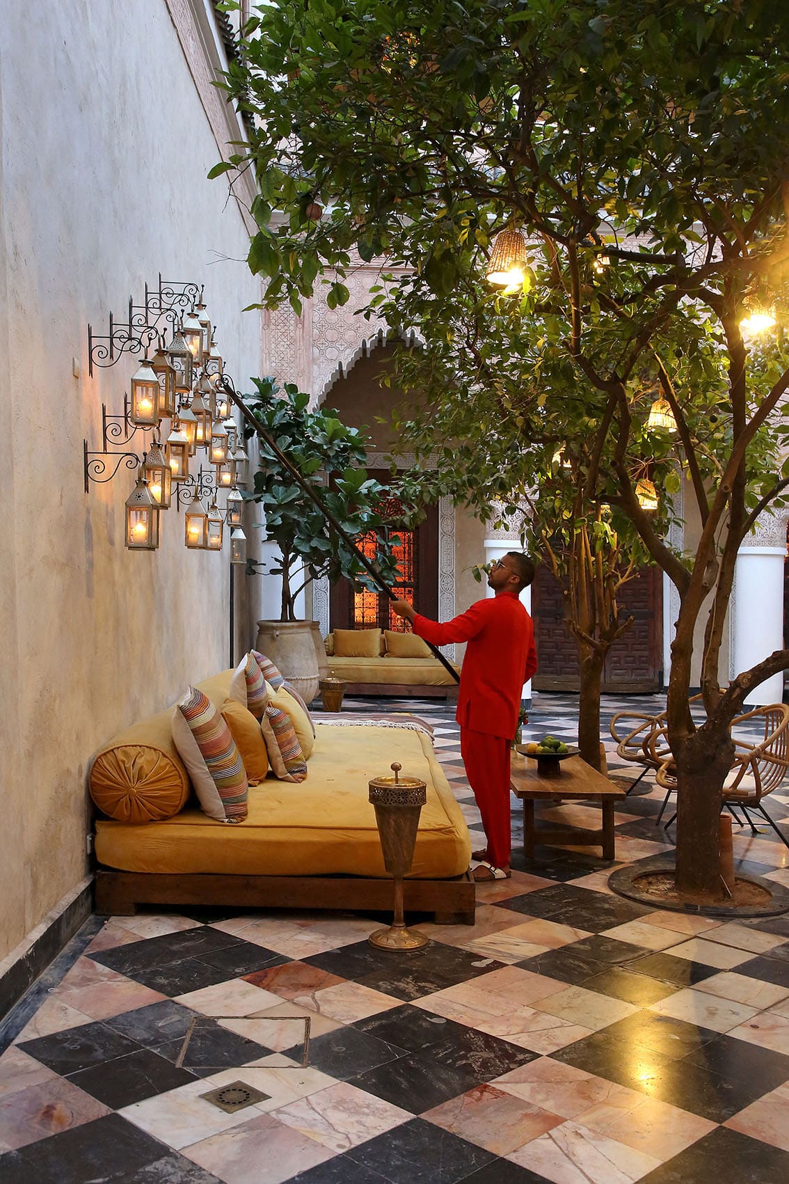 A courtyard with a black-and-white marble floor and a fig tree