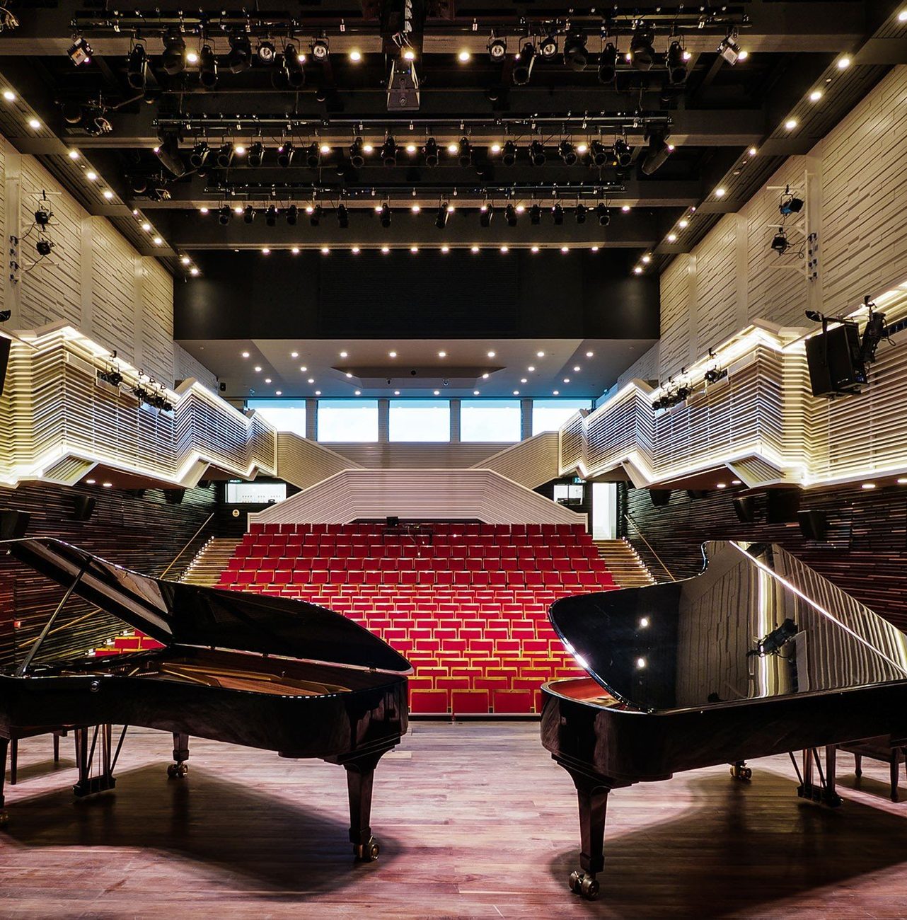 Elma Hall, the concert hall, with two Steinway grand pianos and tiered red seating