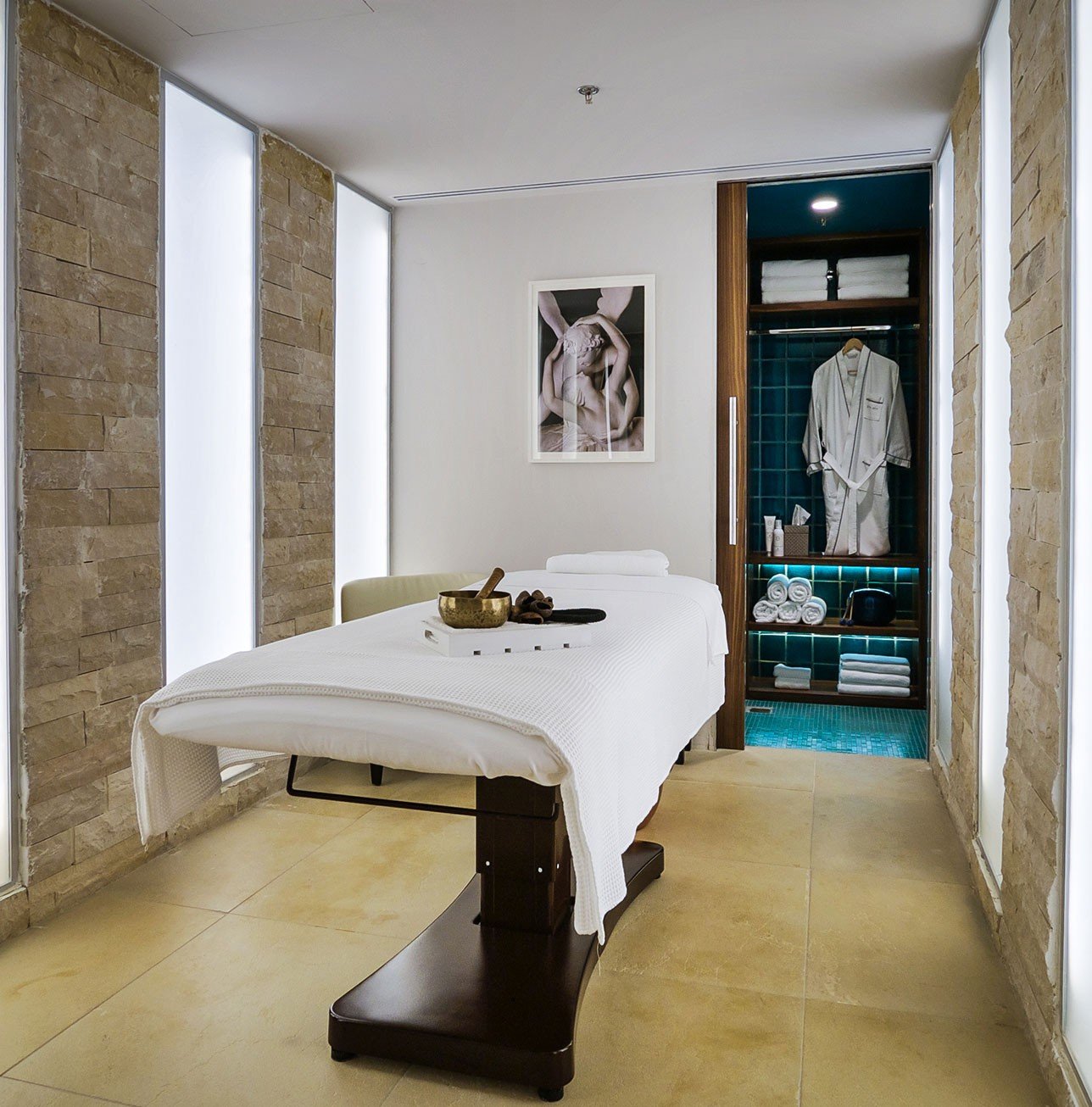 A spa treatment room in stone and white