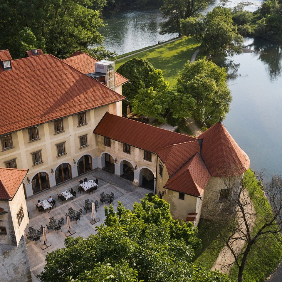 The arcaded courtyard and terrace laid for dinner above the river