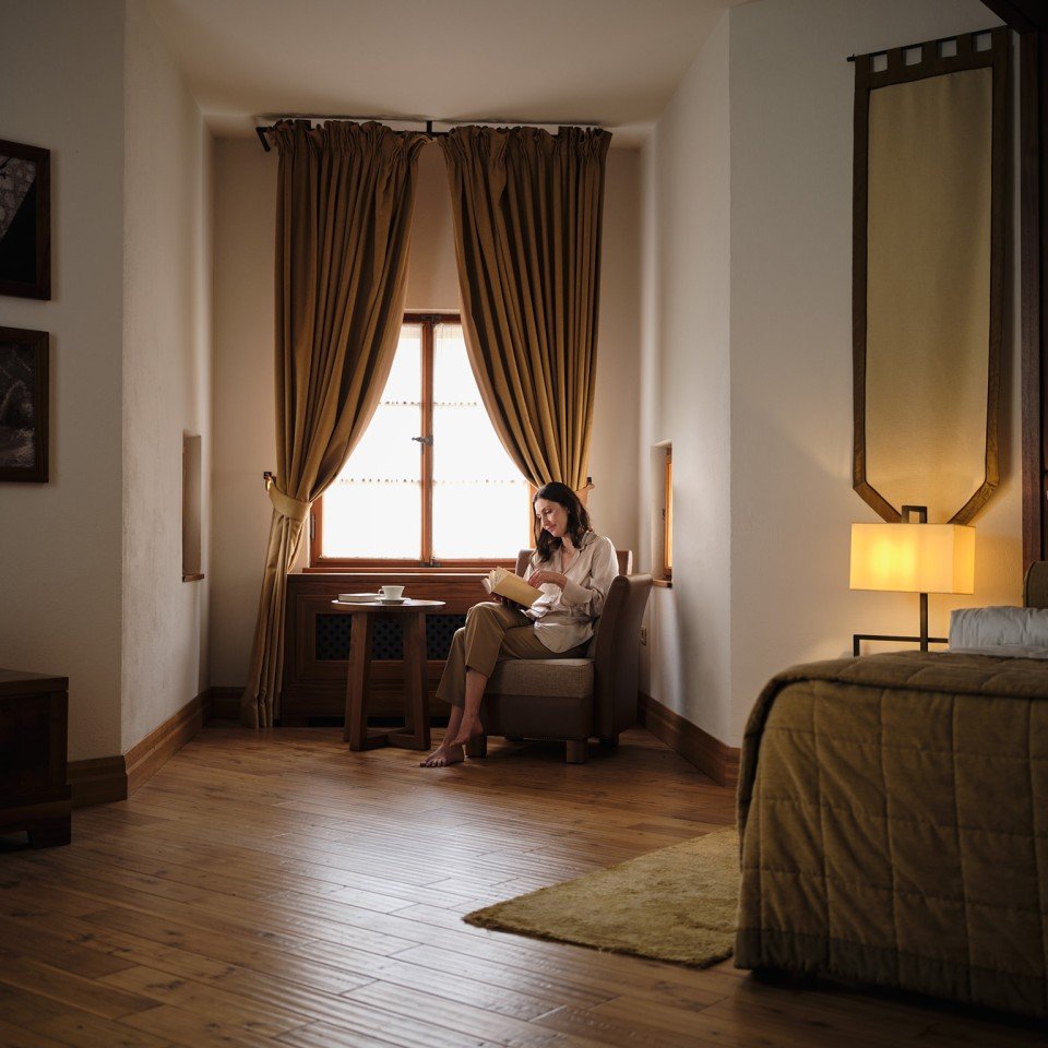 A castle room with a deep window seat and warm evening light