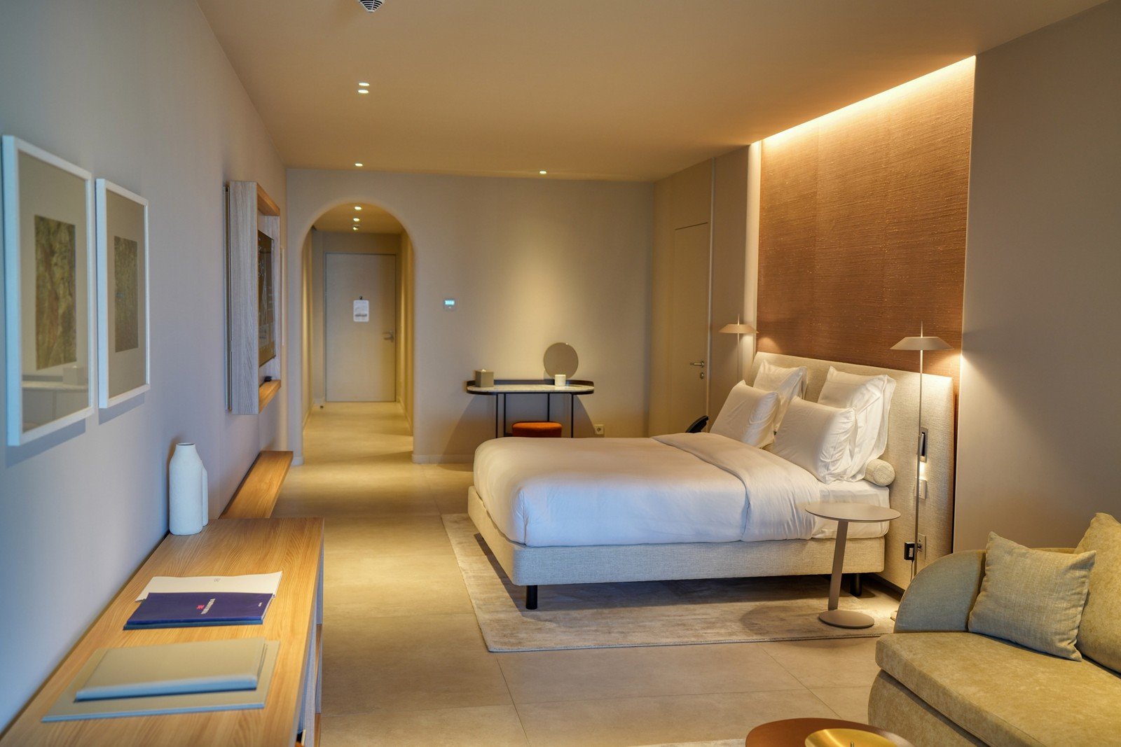 A room with floor-to-ceiling glass and an arched opening onto the Ionian