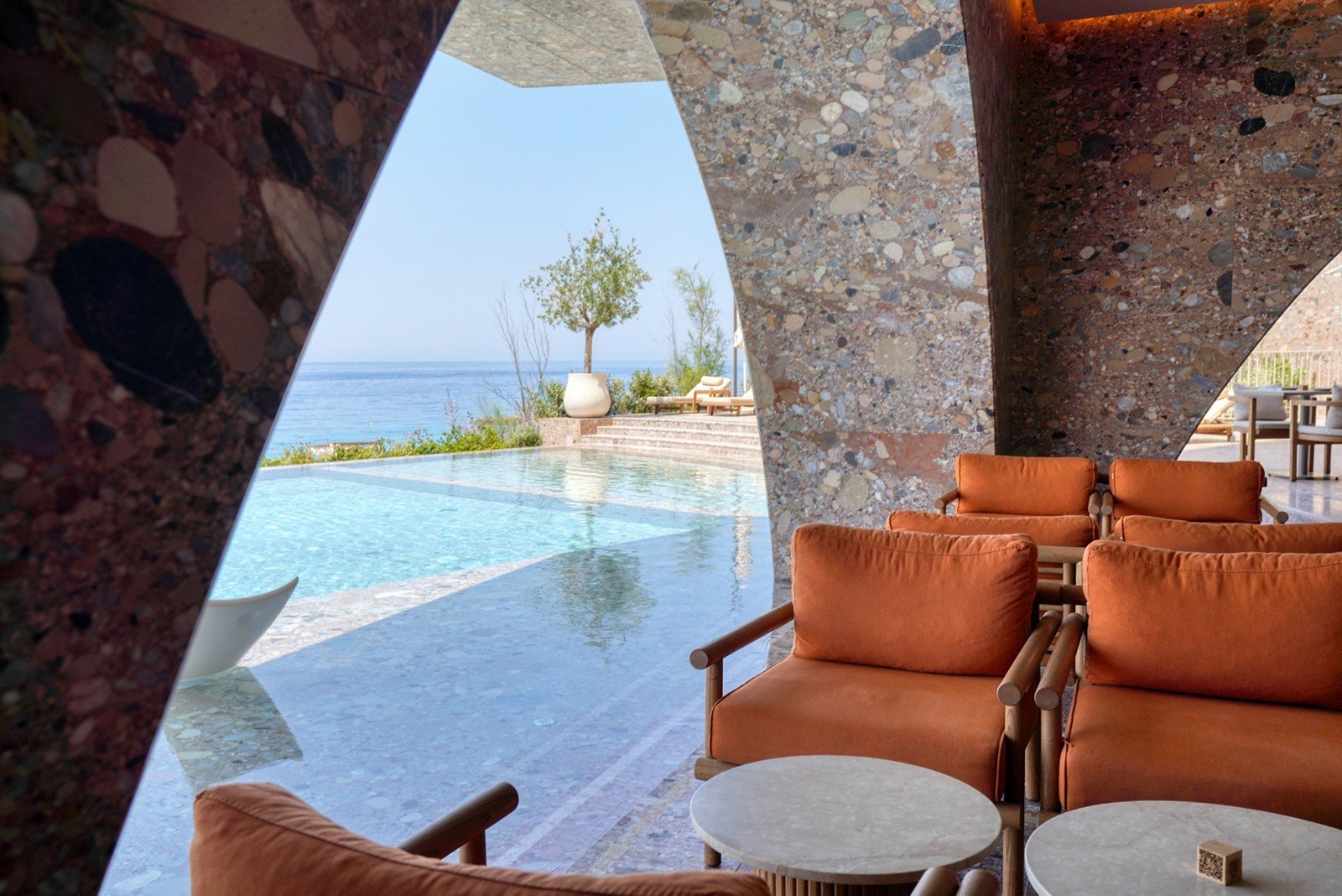 A plunge pool held in quarried stone above the water