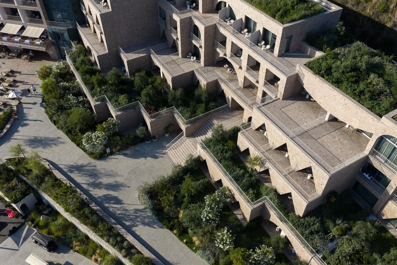 The hotel seen from above, stone terraces stepped into the slope