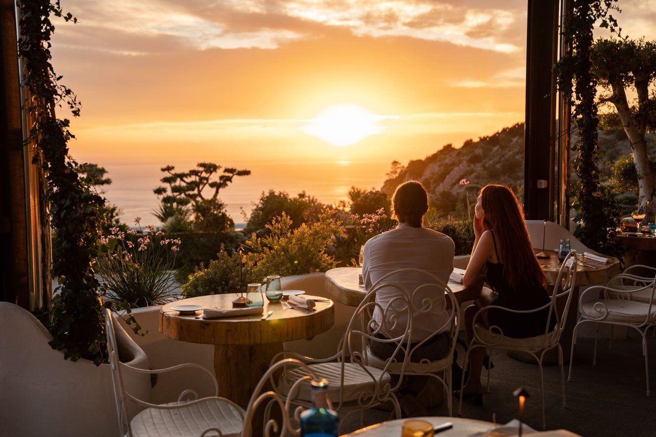 Dinner on the restaurant terrace as the sun sets over the coast