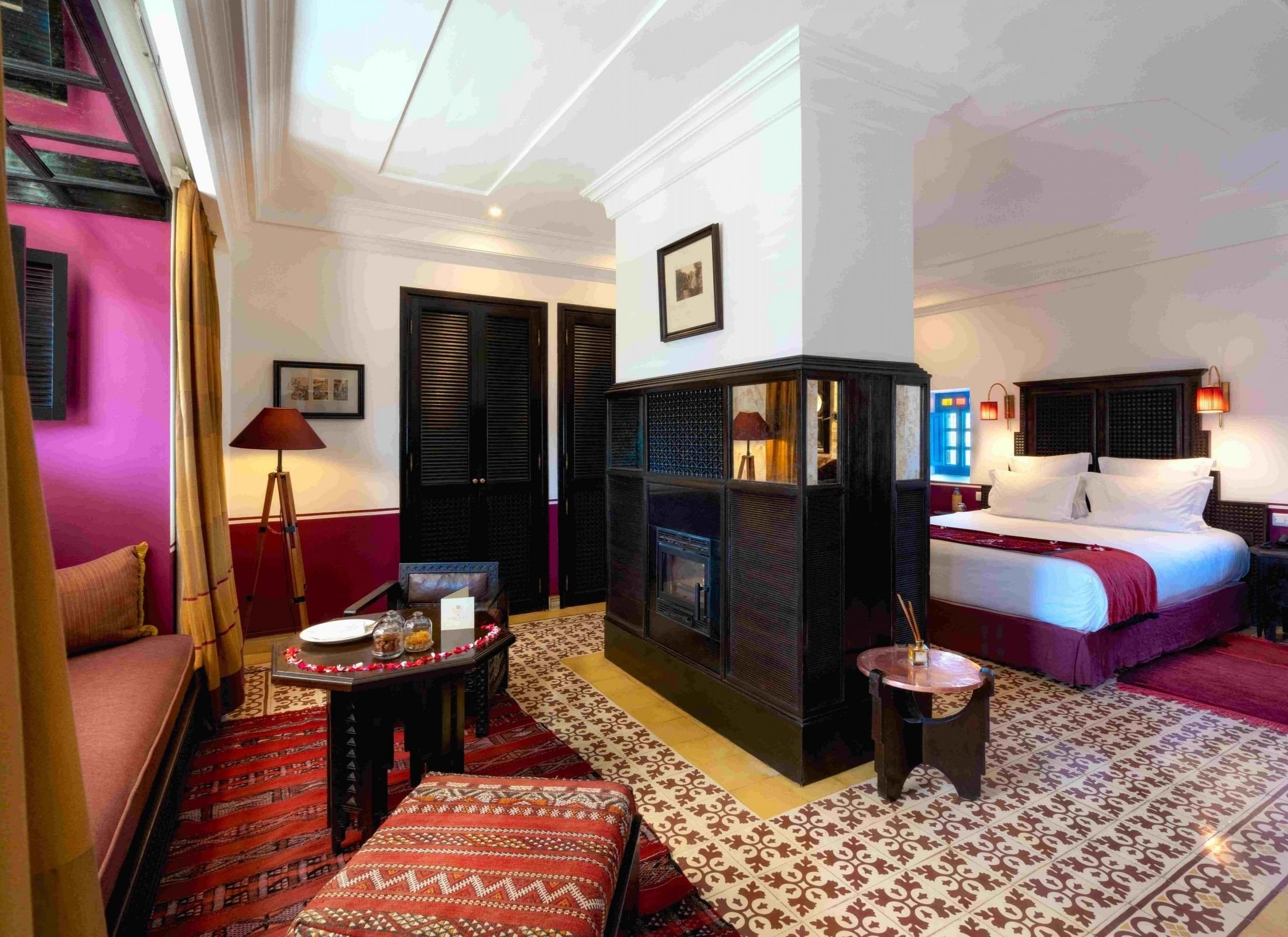 A suite in dark wood and warm colour, Moroccan rugs and a carved screen
