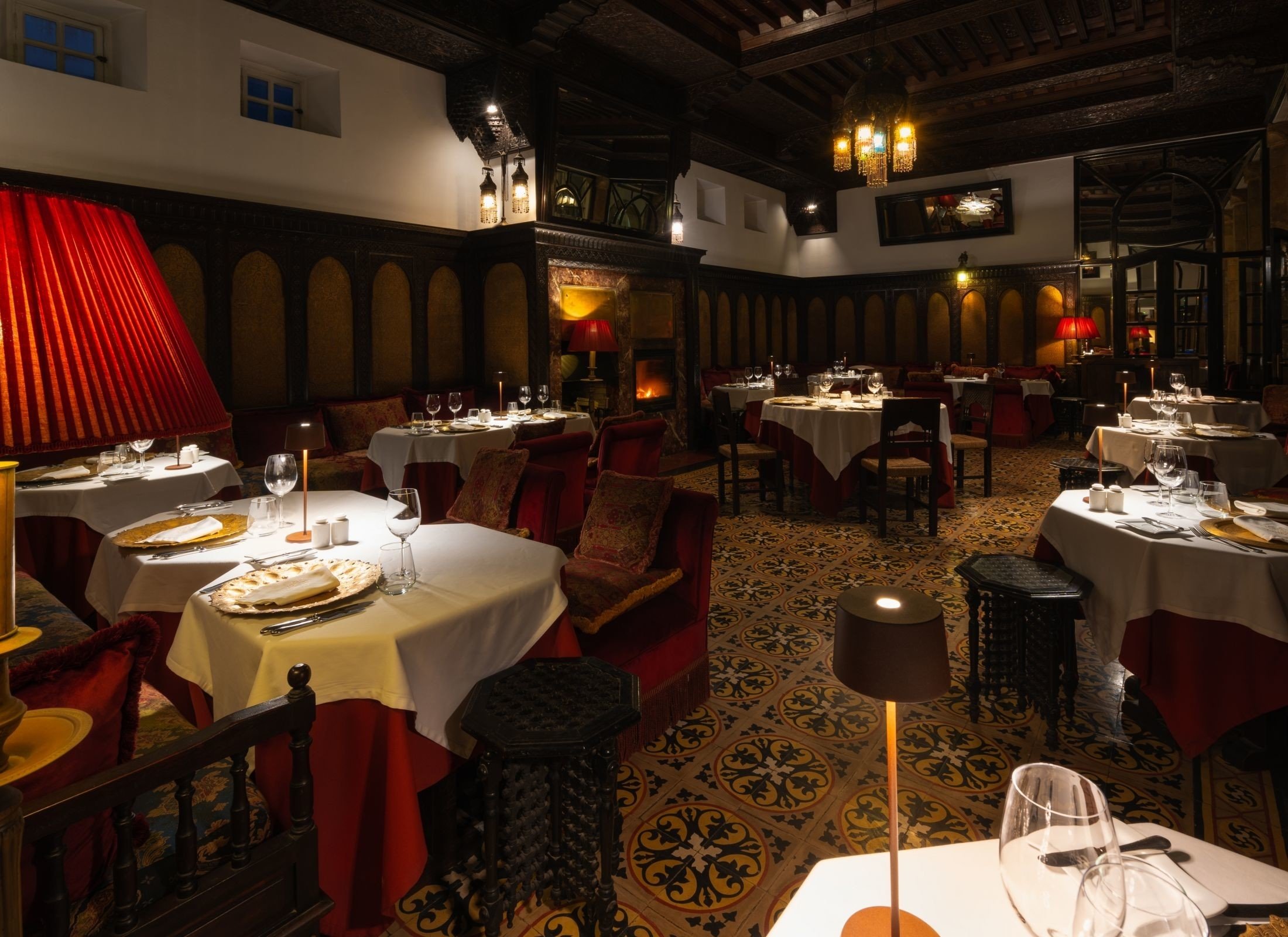 The Salon Anglais dining room, low-lit with red banquettes