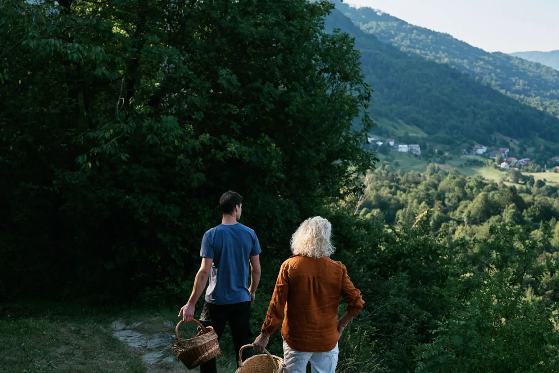 Foraging above the valley with baskets, the village below