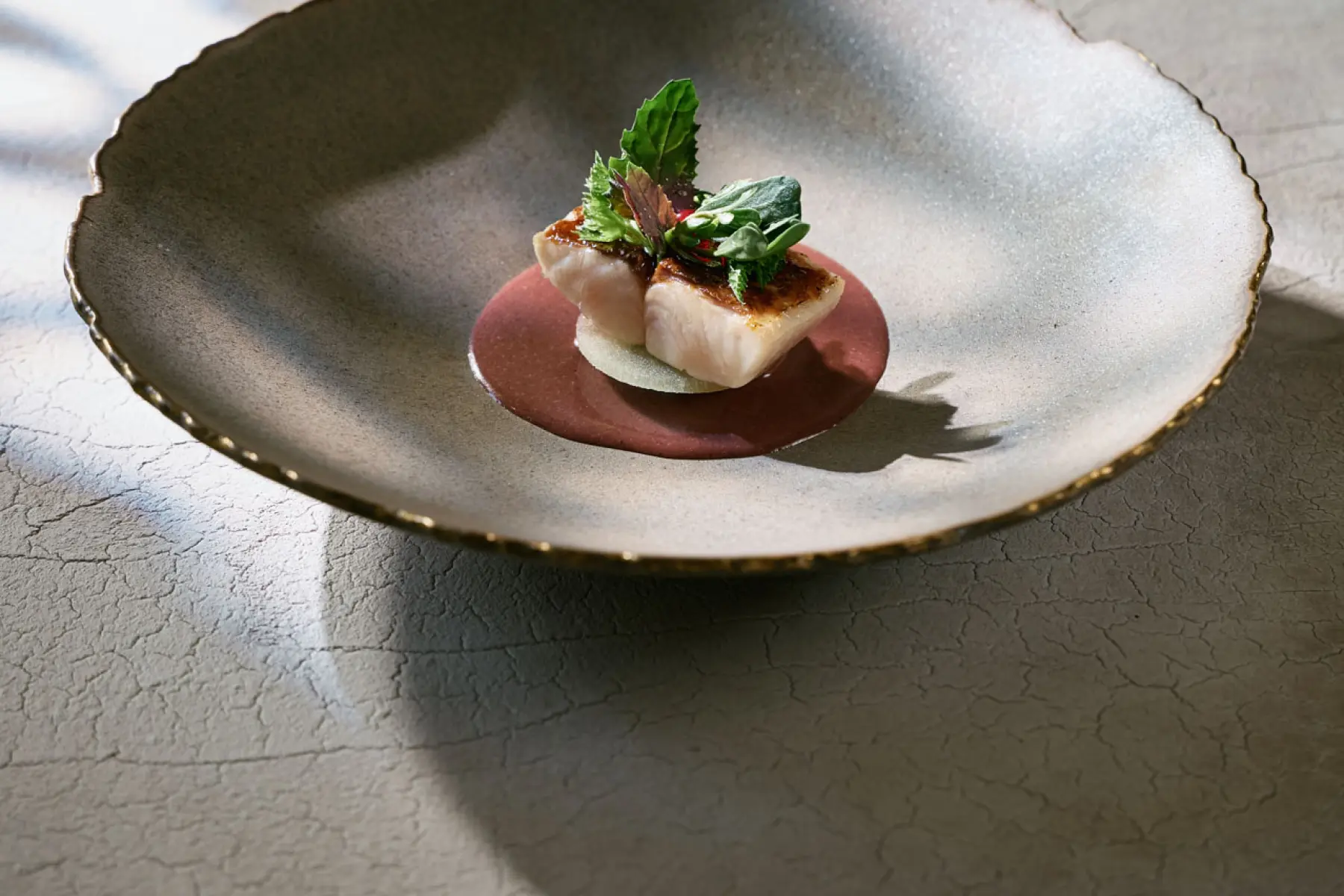 A fish course on a glazed ceramic plate