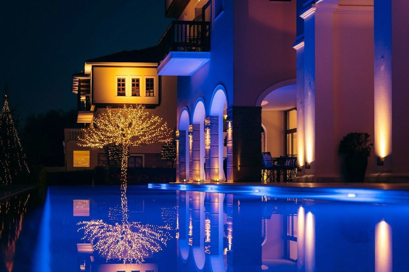 The hotel lit at night and mirrored in the pool