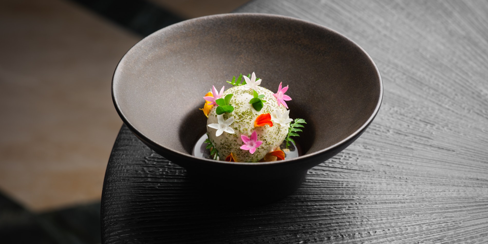 A plated dessert at ION Harbour, dressed with herbs and flowers
