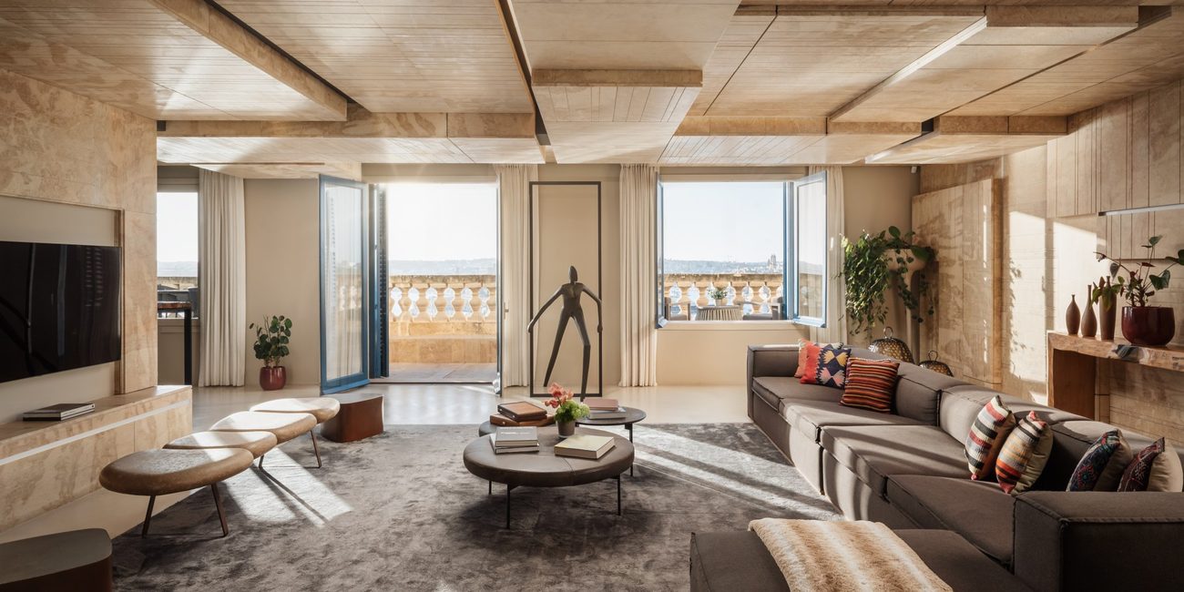 A stone-clad living room opening to a terrace above the Grand Harbour