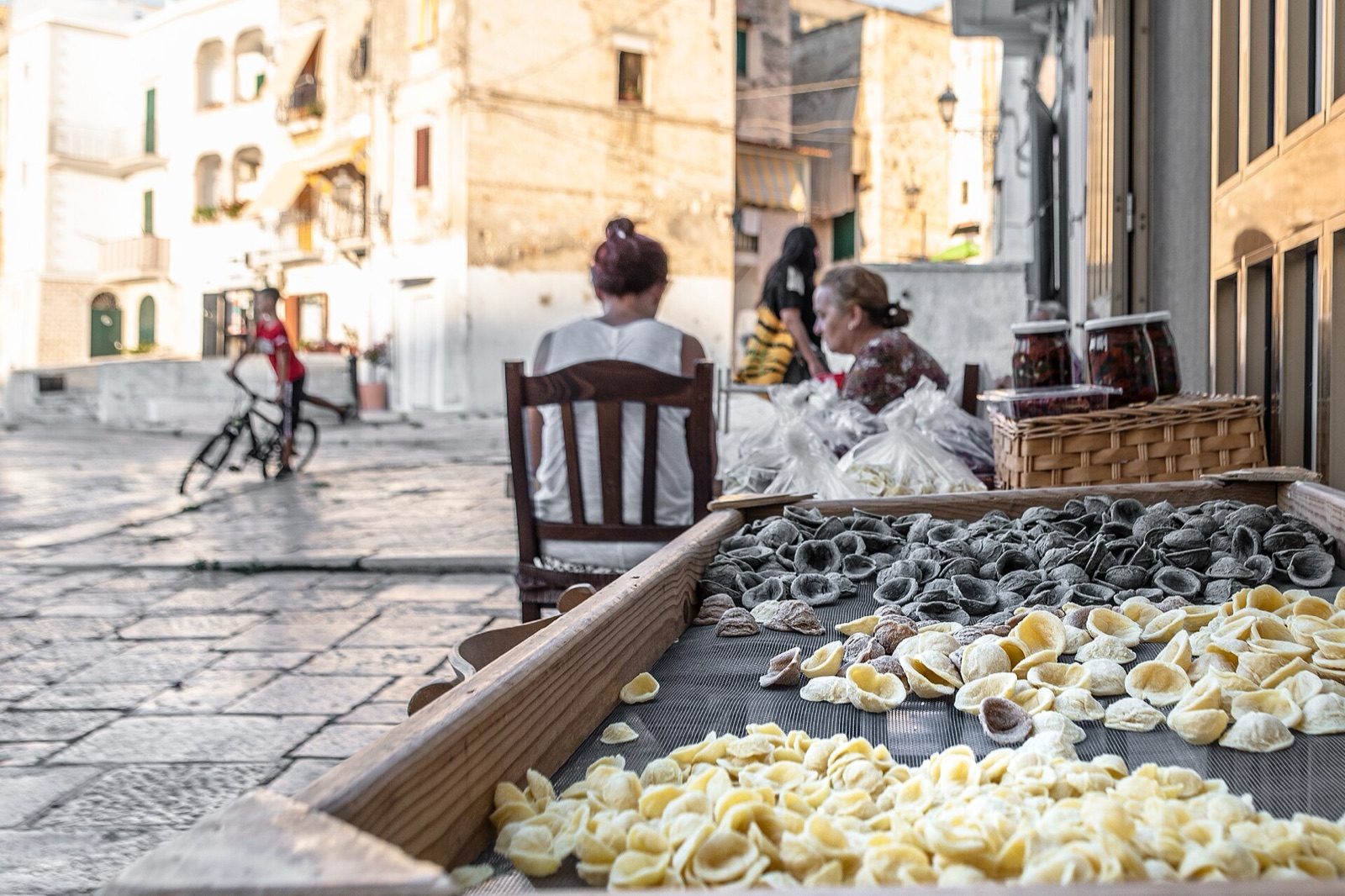 Fresh orecchiette laid out to dry on a board in a Bari lane