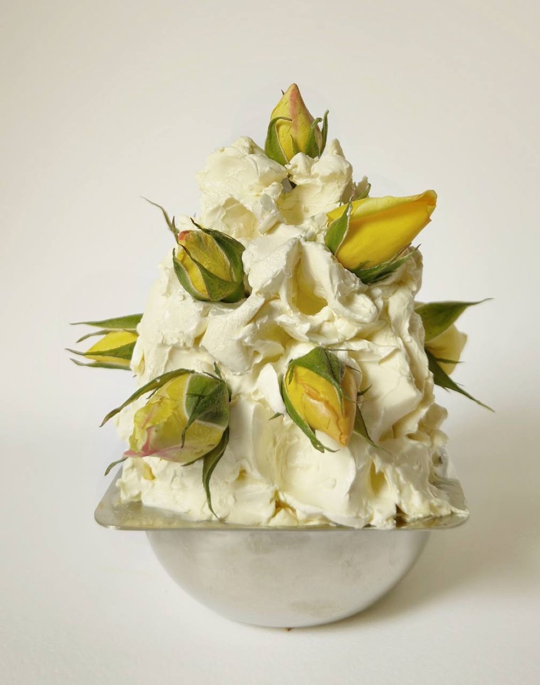 A sculpted mound of cultured butter set with yellow rosebuds