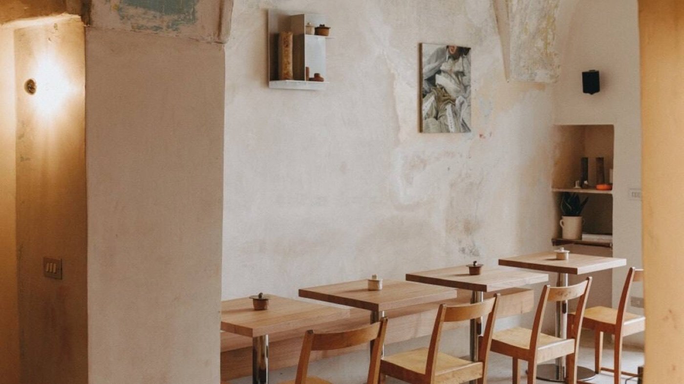 The pared-back dining room of Burro, wooden tables against white plaster walls