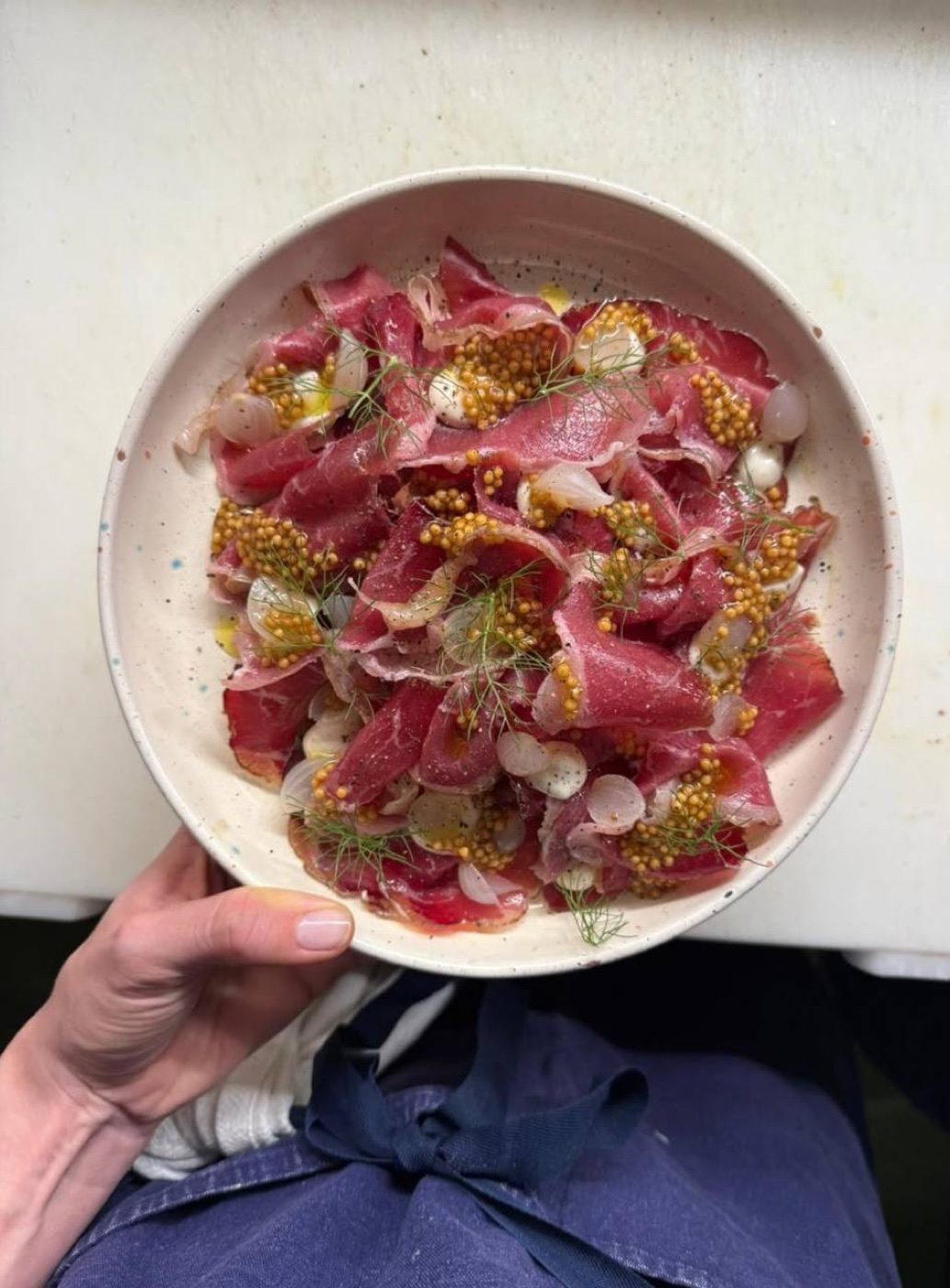 Thin-sliced raw beef with pickled mustard seeds and fennel