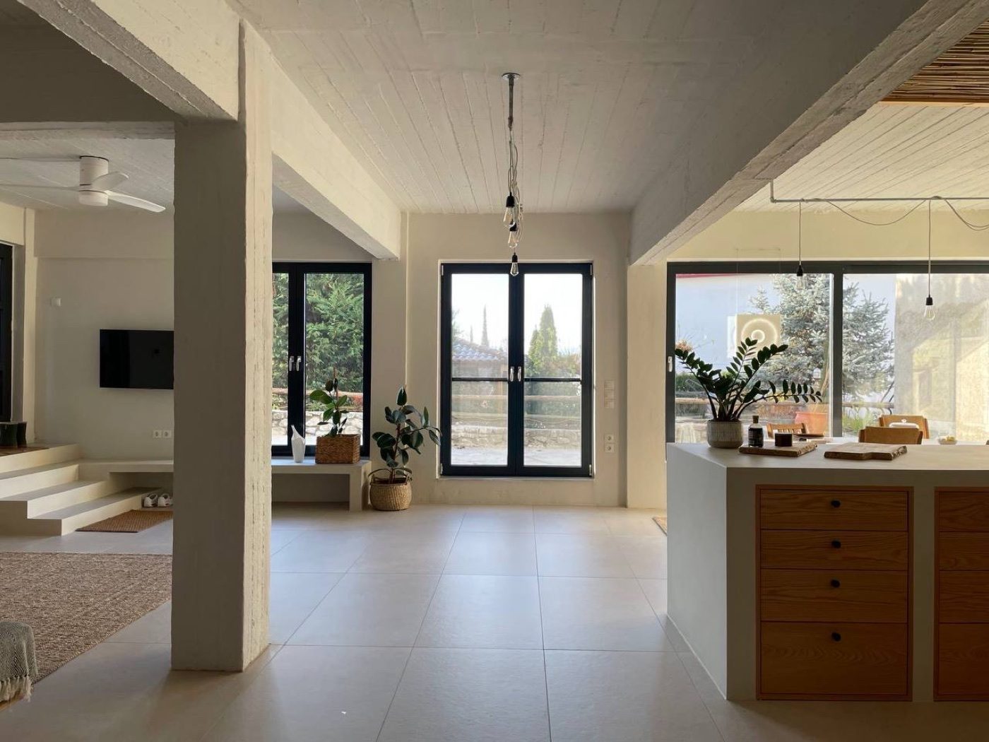The open living space, a step down to the sitting area with garden windows