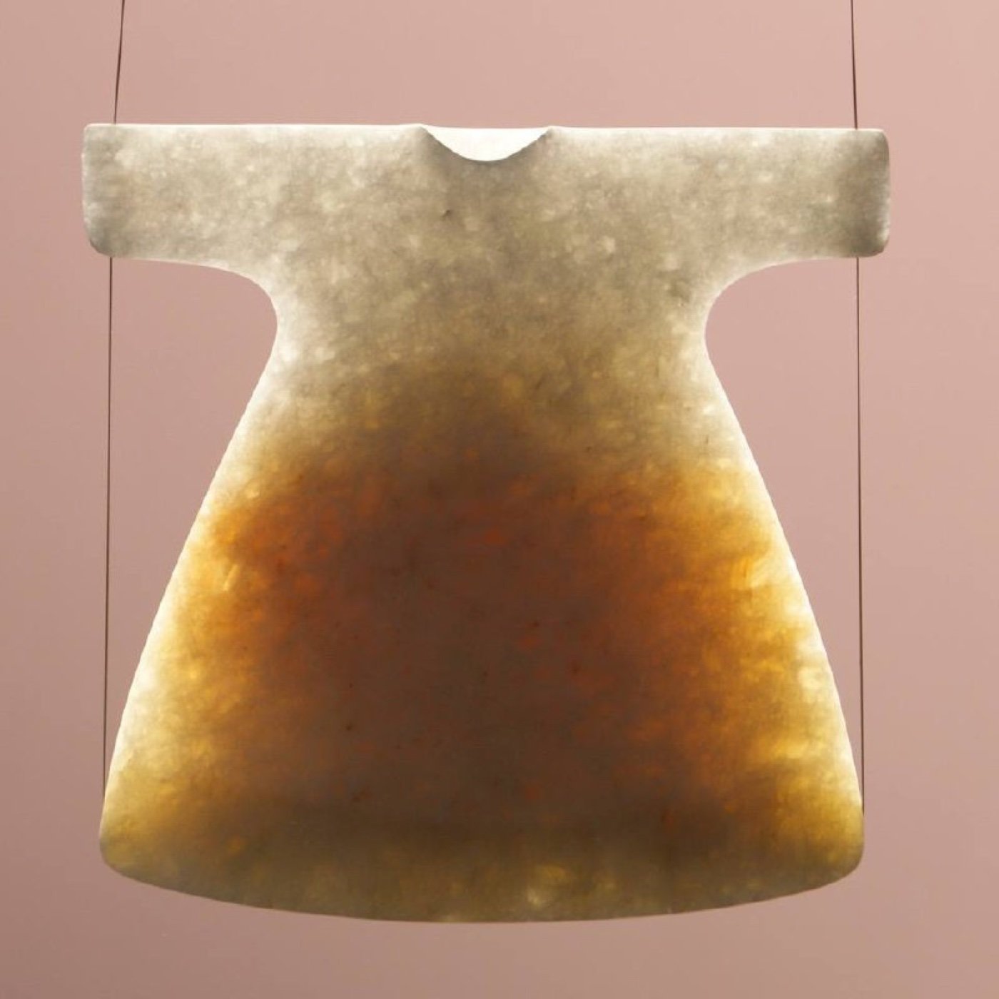A translucent marble robe by Ingbert Brunk, glowing amber with the light held in the stone